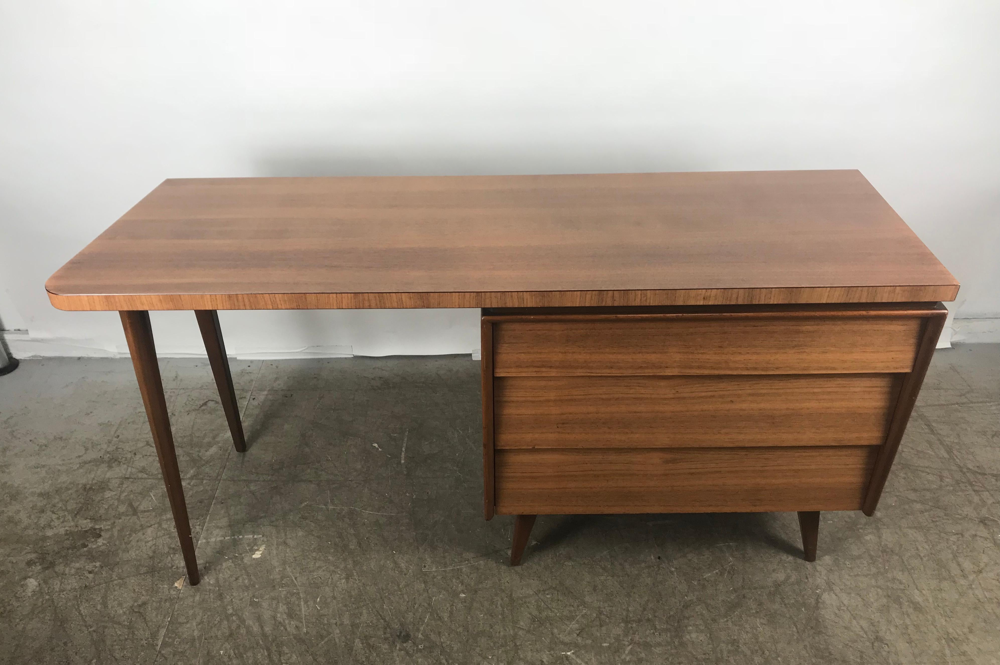 Elegant modernist desk with unusual asymmetrical top made by Mallin Furniture Co..Stunning design, superior quality featuring three generous size drawers, dove tail joinery. Hand delivery avail to New York city or anywhere en route from Buffalo New