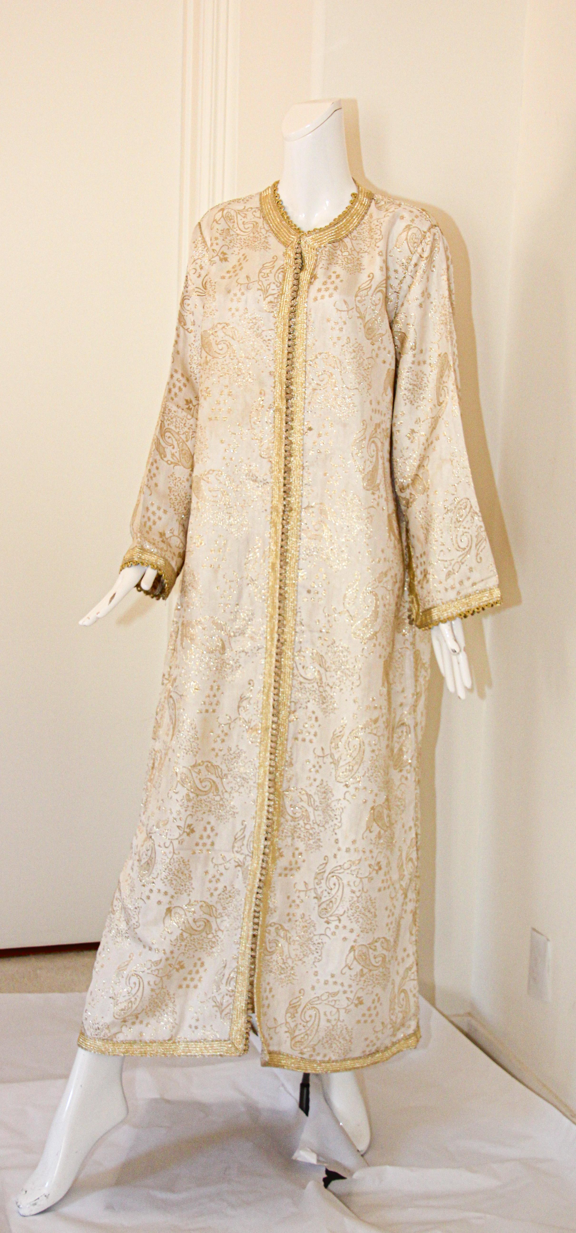 Élégant caftan marocain blanc avec brocart floral métallique doré lamé,
Il s'agit d'un exemple exceptionnel de conception de mode marocaine datant des années 1970,
Fabriqué à la main au Maroc et sur mesure pour un ajustement détendu.
Elle est garnie