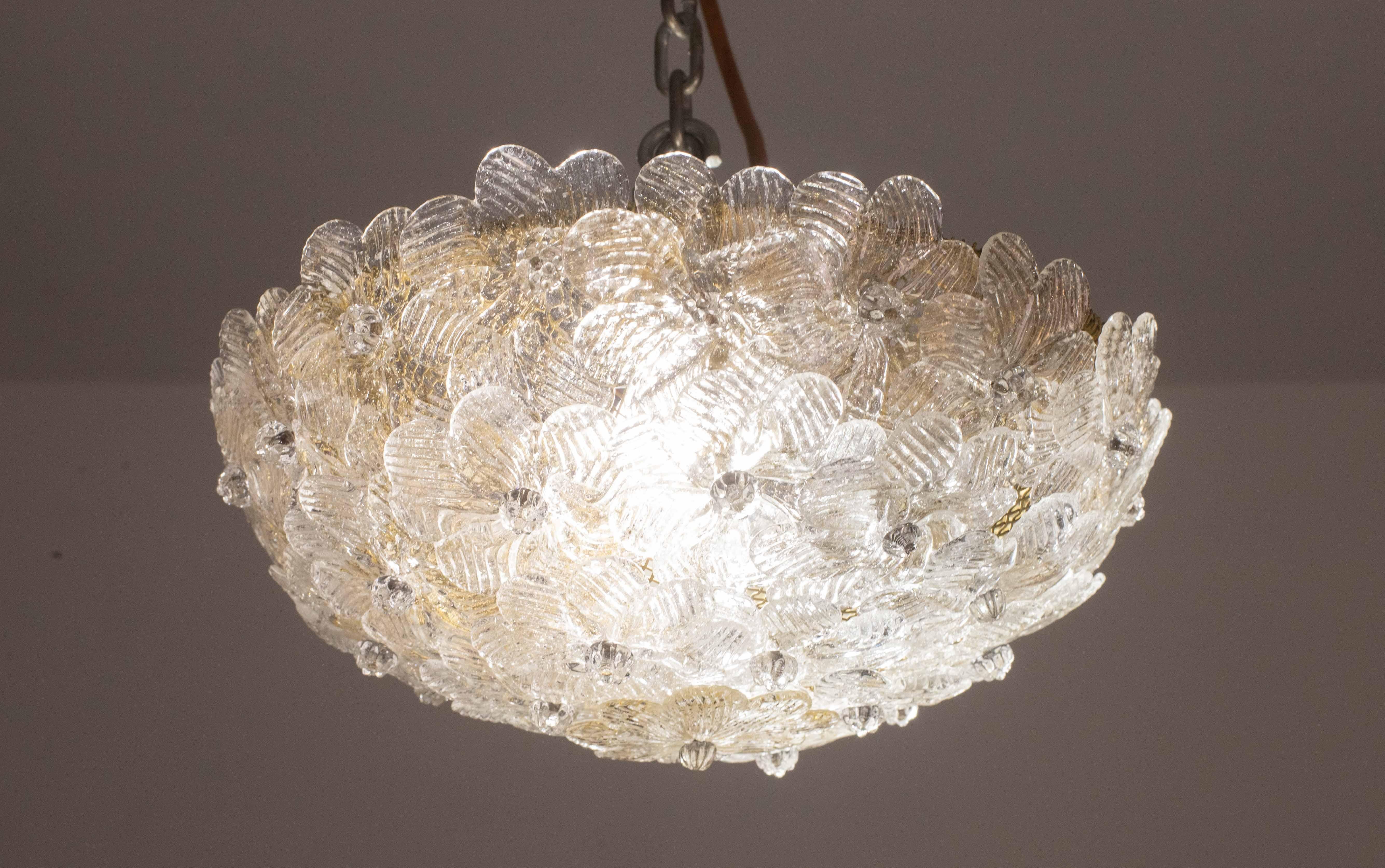 Bonita lámpara de techo de dos luces con flores de cristal de Murano, fabricada por Seguso para Venini, Italia, años 60.
Cesta de techo metálica con flores superpuestas de cristal de Murano soplado a mano en color dorado y transparente con