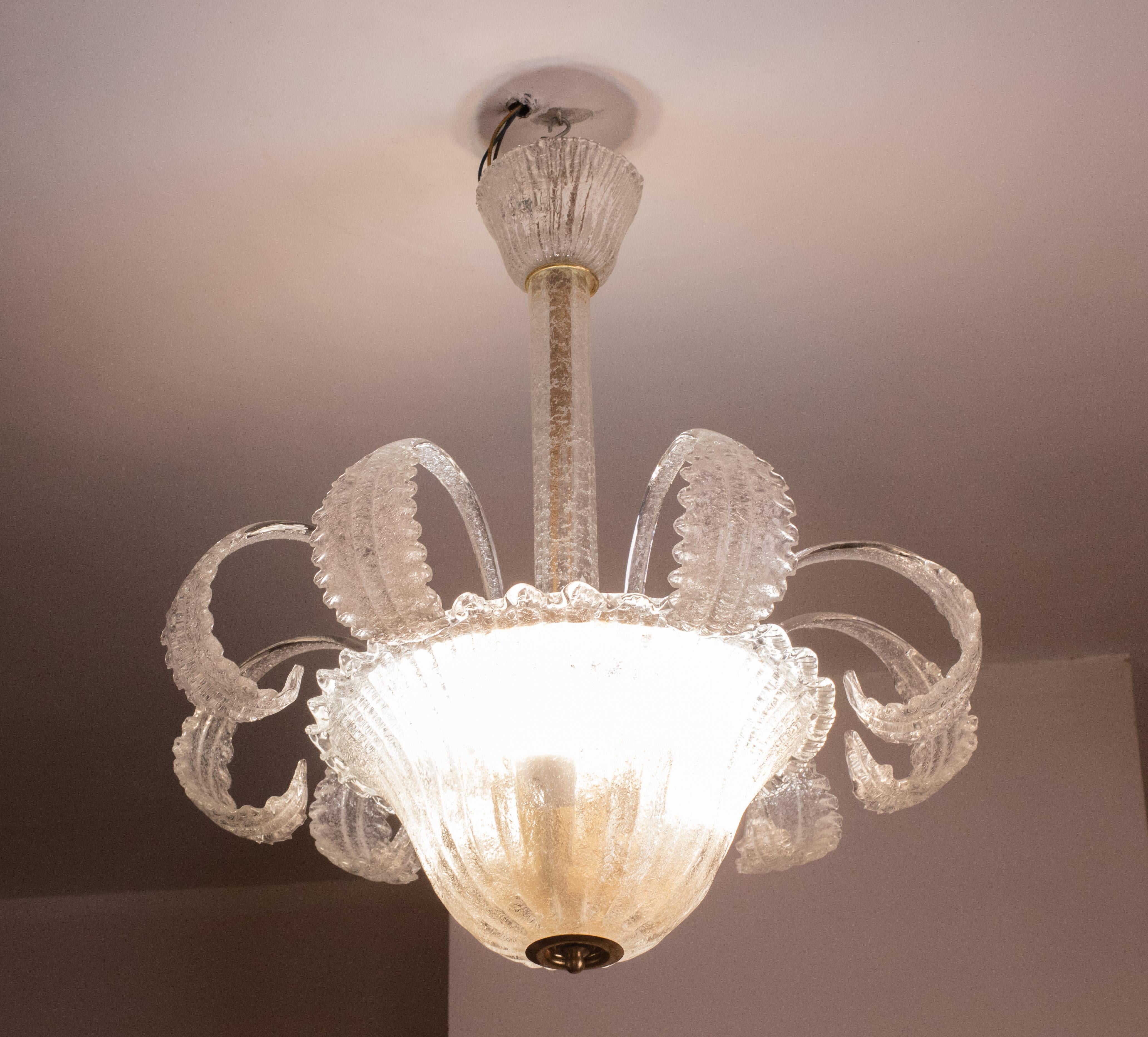 Elegant Murano chandelier composed on the outside of only glass elements.

The chandelier consists of a rosette a trunk and an impressive central disk, all decorated with 9 beautiful leaves.

The height measures 70 centimeters, the diameter 60