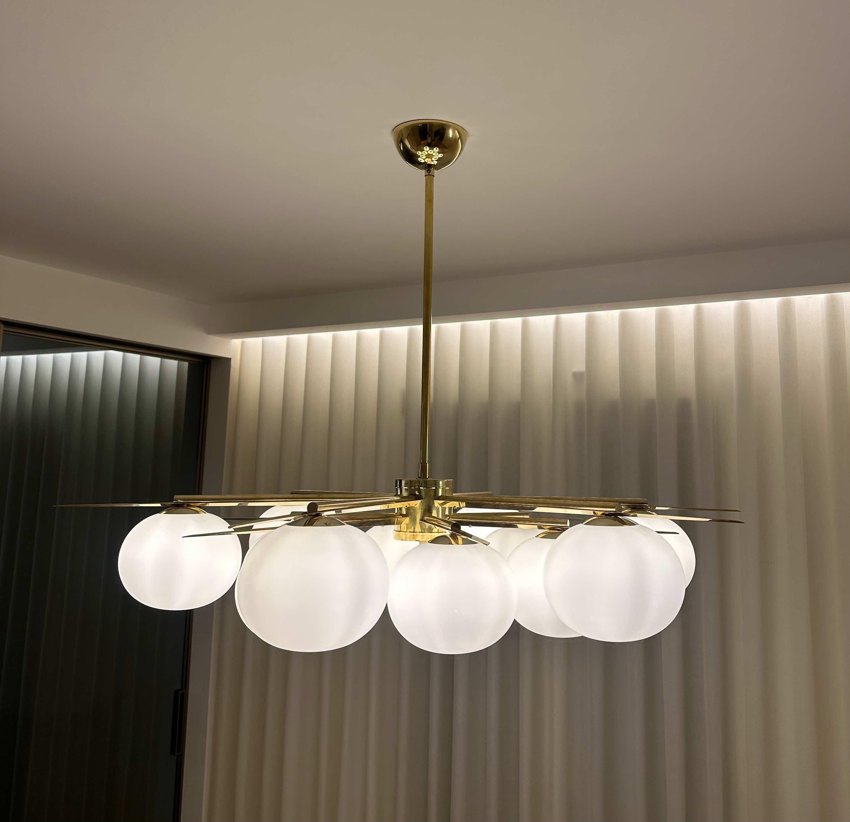 The chandelier features an elegant design, with a classic brass structure. The 12 Murano glass spheres add a handmade, refined touch. Rewired by professionals, it has been restored to ensure modern safety and functionality while preserving its