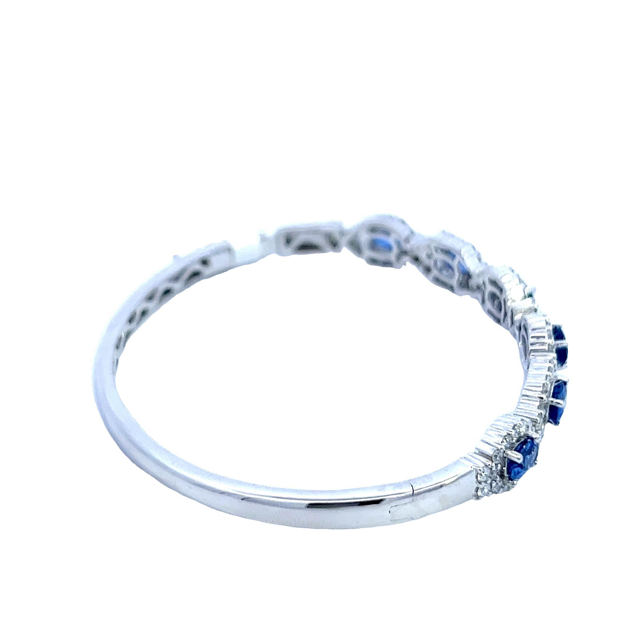 Adorn your wrist with the epitome of sophistication - an exquisite 3.03-carat oval natural sapphire bangle bracelet, meticulously designed in gleaming 14k white gold. The centerpiece of this bracelet is a mesmerizing 6x4mm natural sapphire, known