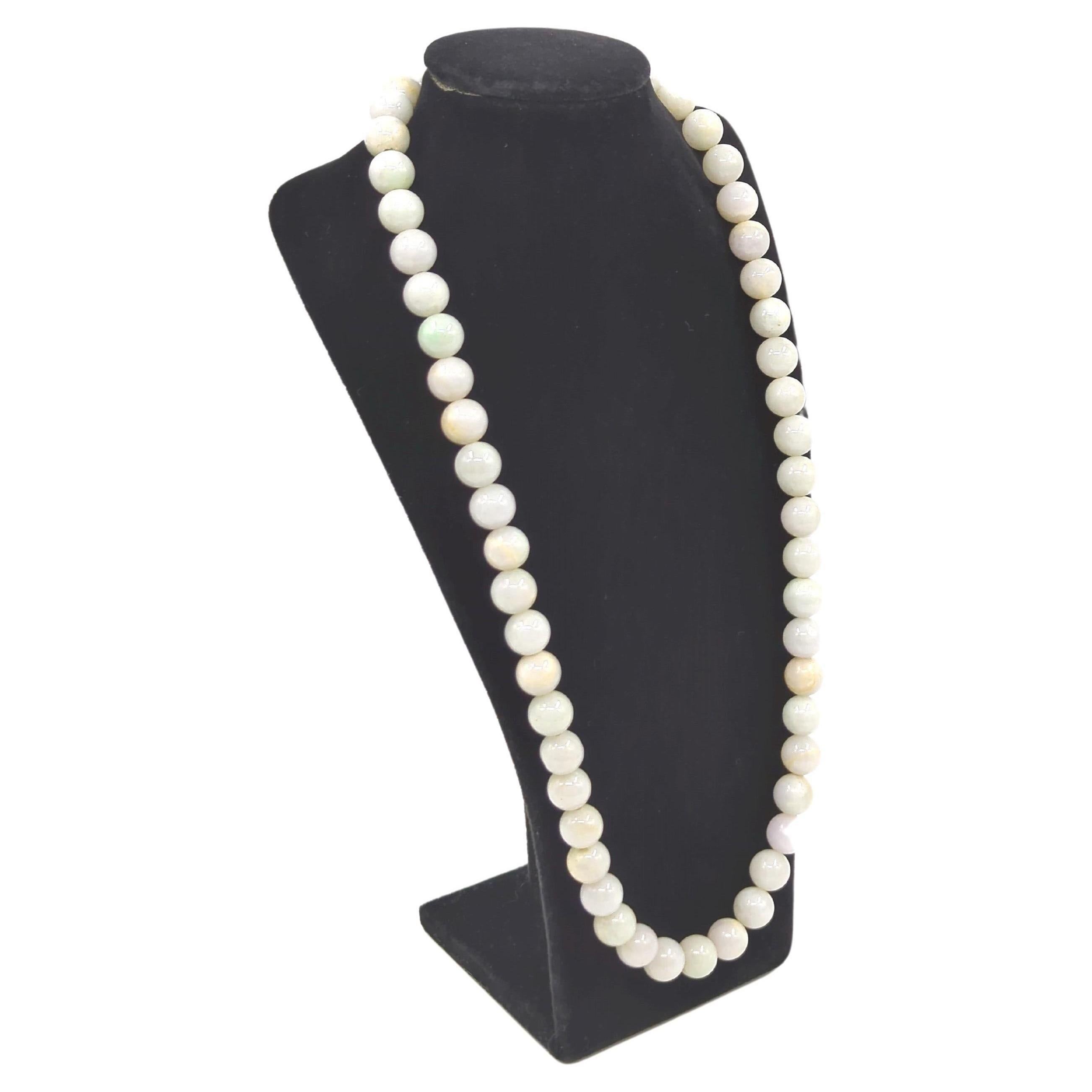 This mid-century natural jadeite beaded necklace is comprising of 55 meticulously selected jadeite beads, each measuring approximately 11mm in diameter, the necklace achieves a total length of 23 inches, making it a versatile and sophisticated
