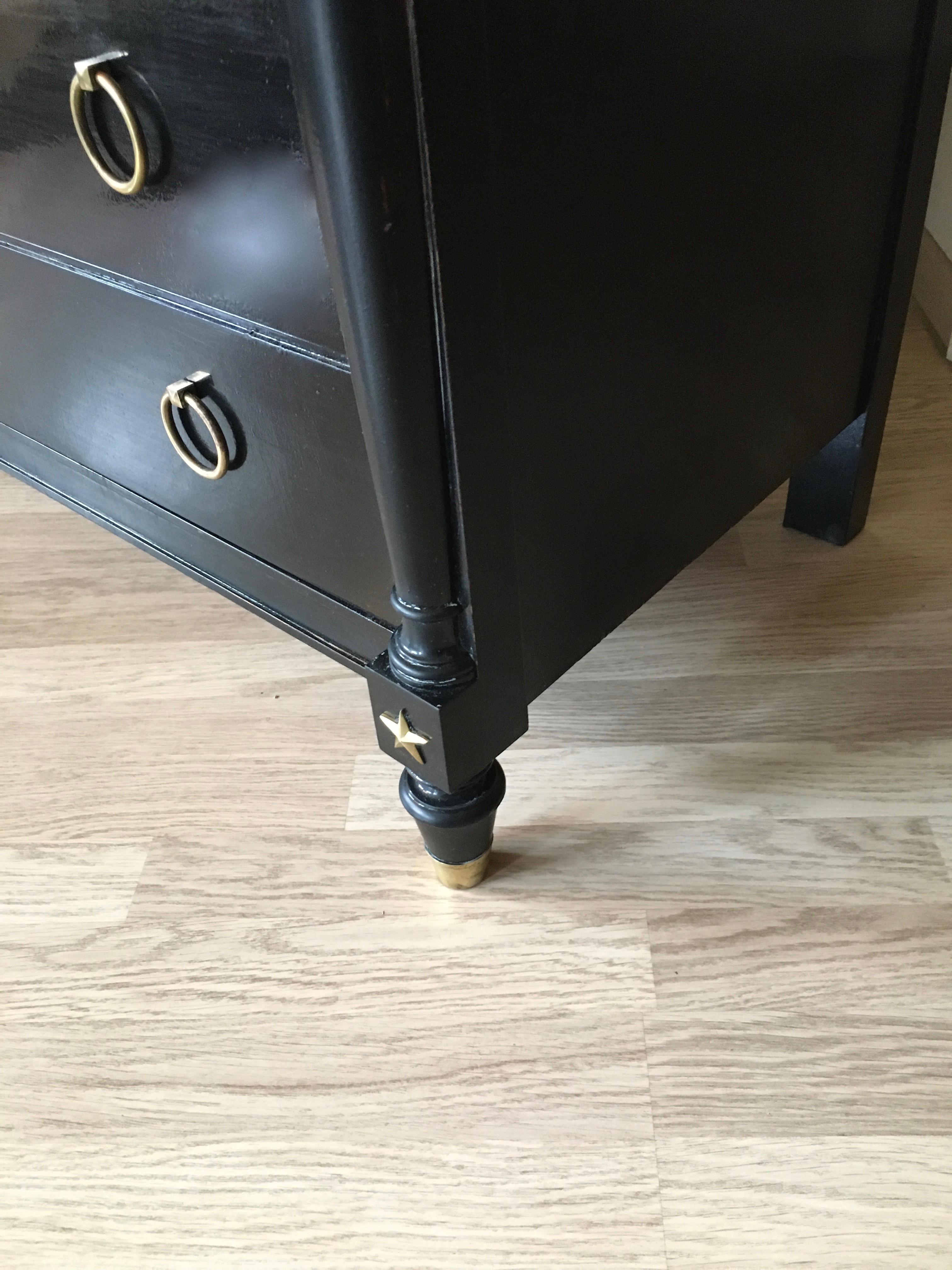 Black lacquered neoclassical chest of drawers with brass pull rings handles and four bronze stars on the front.
Four drawers, the top one with his original brass key and lock.
French forties.