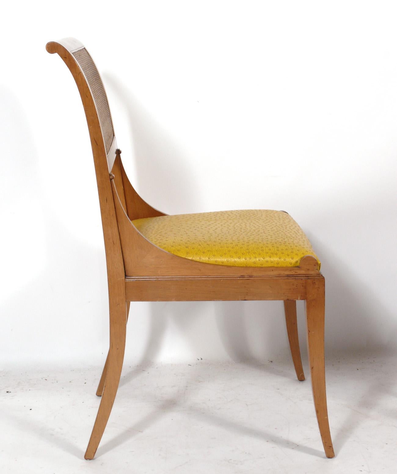 Élégant ensemble de quatre chaises de salle à manger néoclassique, américain, vers les années 1950. Ils ont conservé leur revêtement d'origine en vinyle jaune vif imprimé autruche.