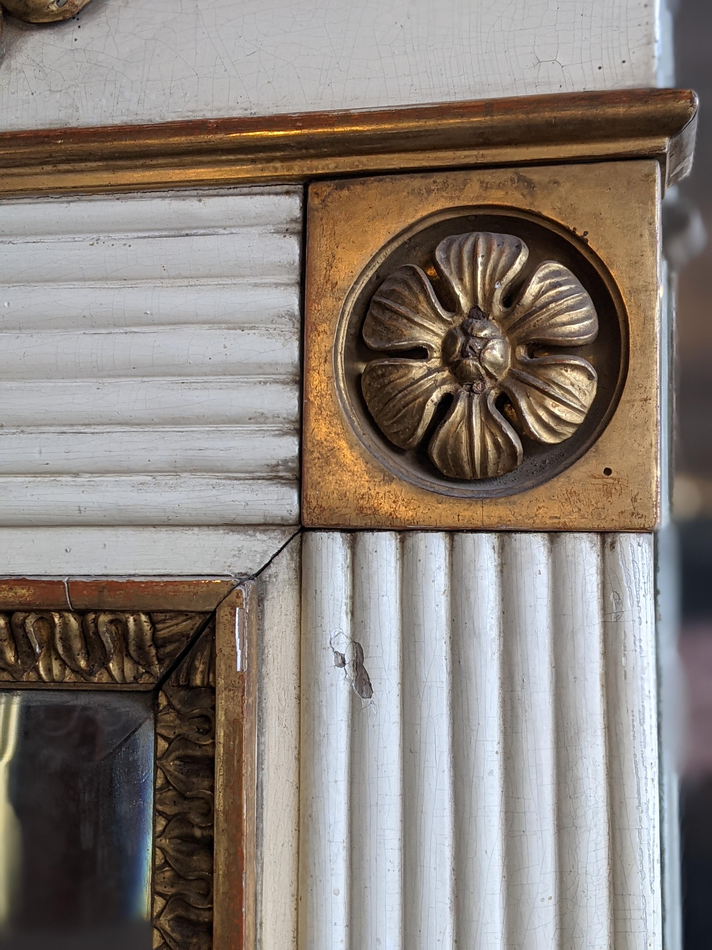 Early 1800 neoclassical fireplace mirror, in ivory painted wood decorated with gilded friezes with gilded floral and vegetable motifs.

Please note that all of our items are shipped after a microwave woodworm treatment, grouting woodworm holes and