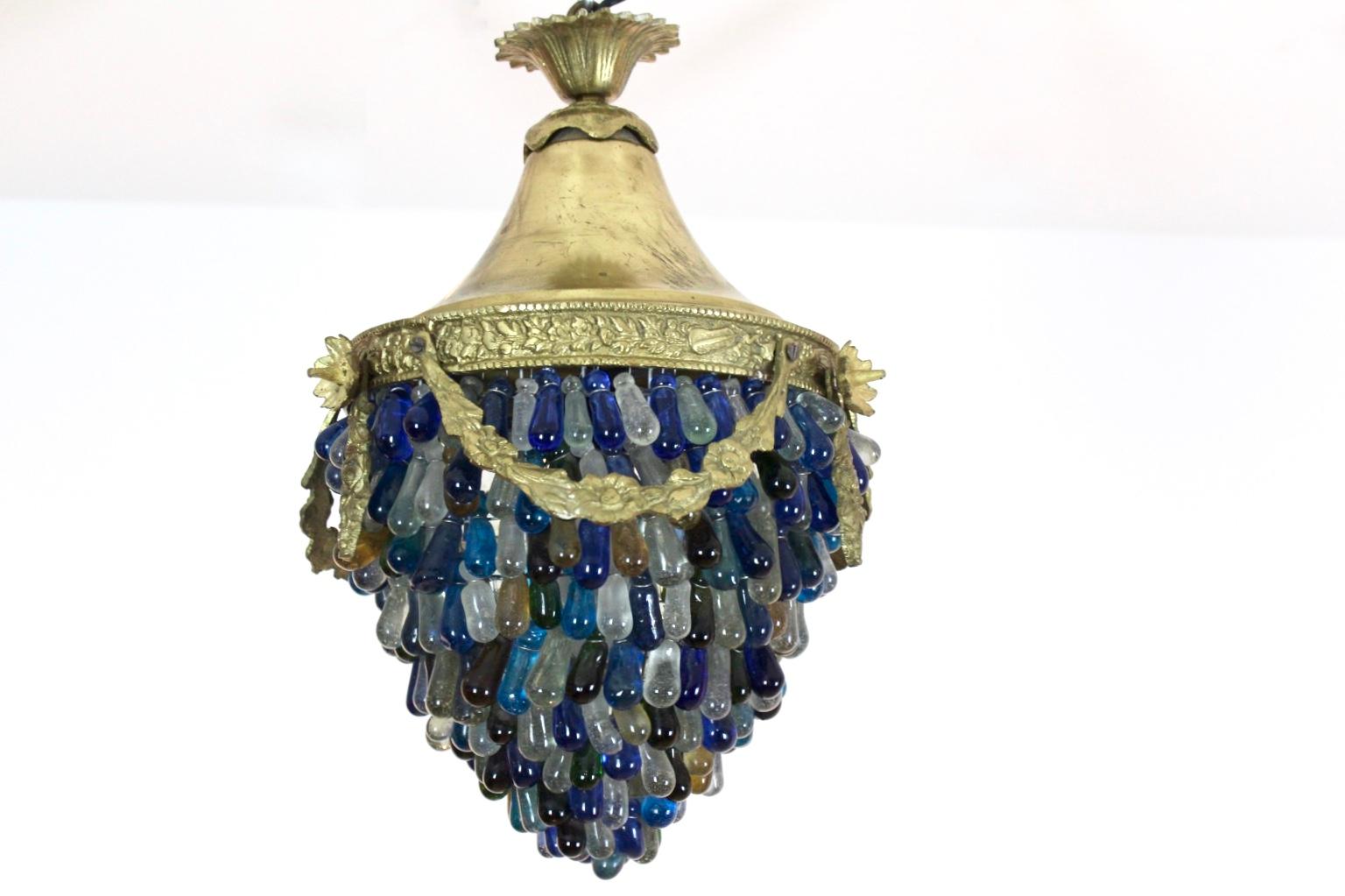 An elegant neoclassical acorn form ceiling fixture composed of brass and colorful Italian Murano Glass drops. Produced in Italy in the 1950s. Consisting of many transparent, green, white, amber, yellow and blue individually handmade teardrops-shaped