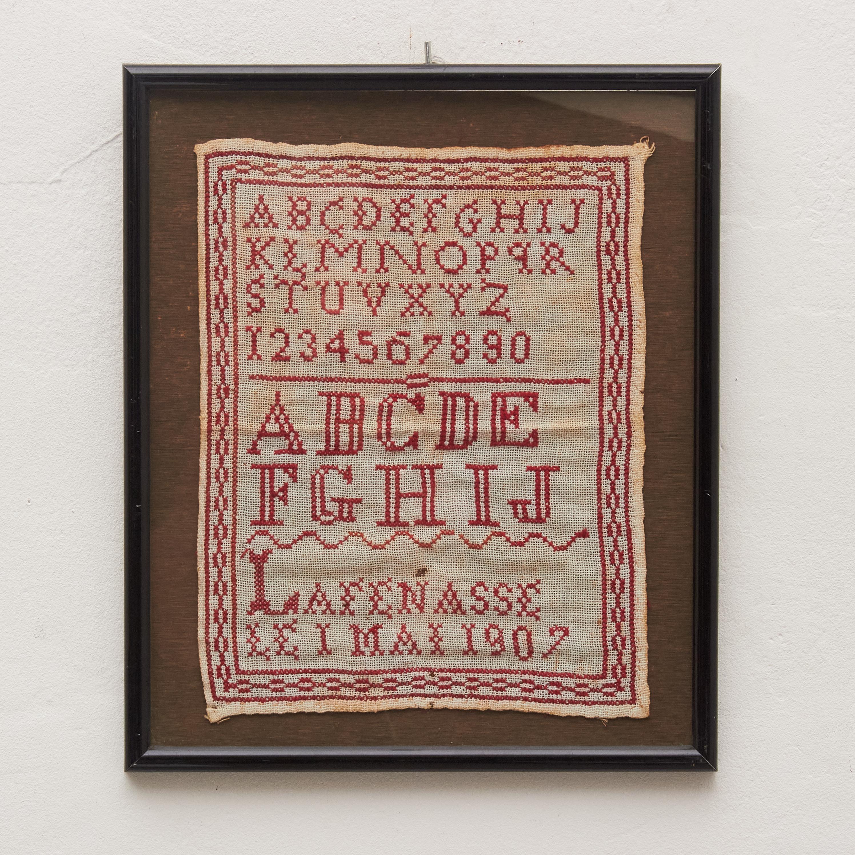 Transport yourself to a bygone era with our vintage cross-stitch sampler from the early 20th century. This timeless piece features a classic red-on-white design adorned with meticulously crafted alphabet letters, numbers, and an enchanting border