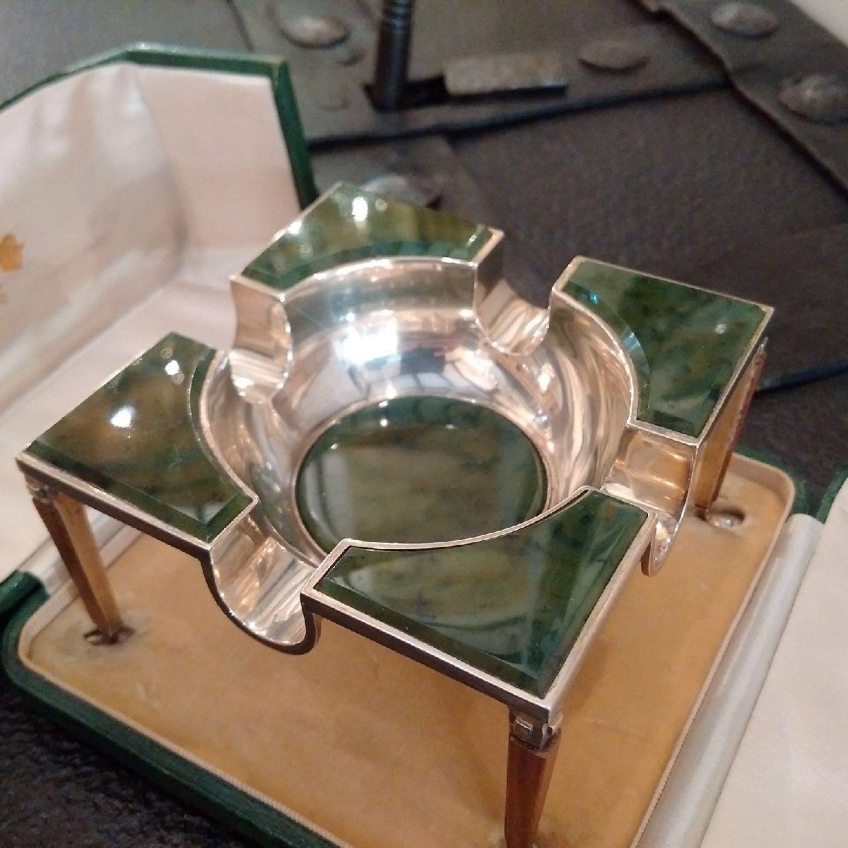 Kendall & Co. of Paris

A highly unusual green onyx and Sterling silver cigar ashtray, the central bowl also lined with onyx features four, wide cigar rests, and the tray is set on four tapered furniture-style legs, with hardwood trim all