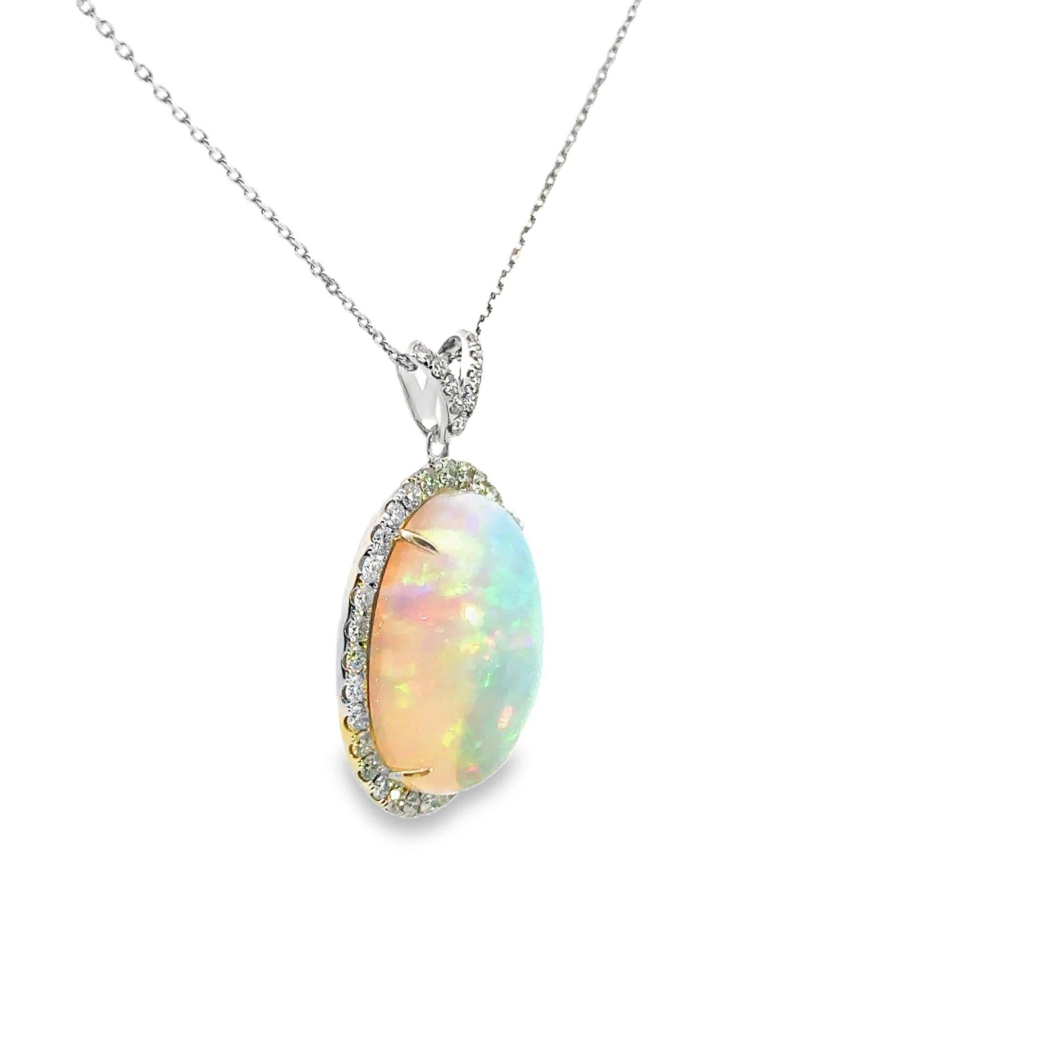 Questa splendida collana con ciondolo in opale presenta un'incantevole opale ovale circondata da un'aureola di diamanti scintillanti. I colori cangianti dell'opale cambiano meravigliosamente con la luce, rendendolo un pezzo accattivante per ogni