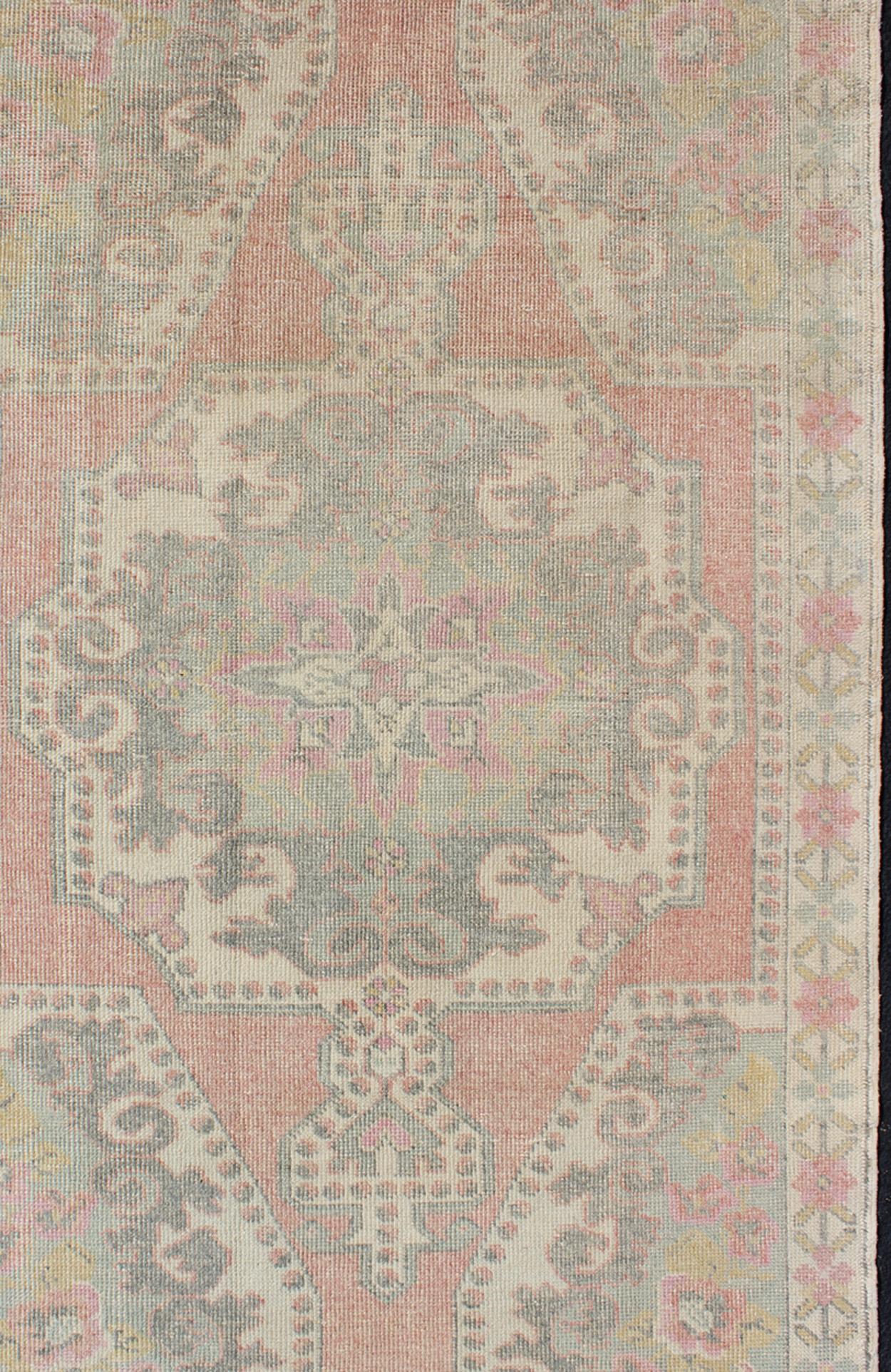 Tappeto vintage rosa, verde chiaro e avorio con motivo a medaglioni floreali, tappeto EN-176597, paese d'origine/tipo: Turchia / Oushak, circa 1940
Questo tappeto oushak d'epoca presenta un bellissimo motivo floreale su sfondo rosa, nei toni del