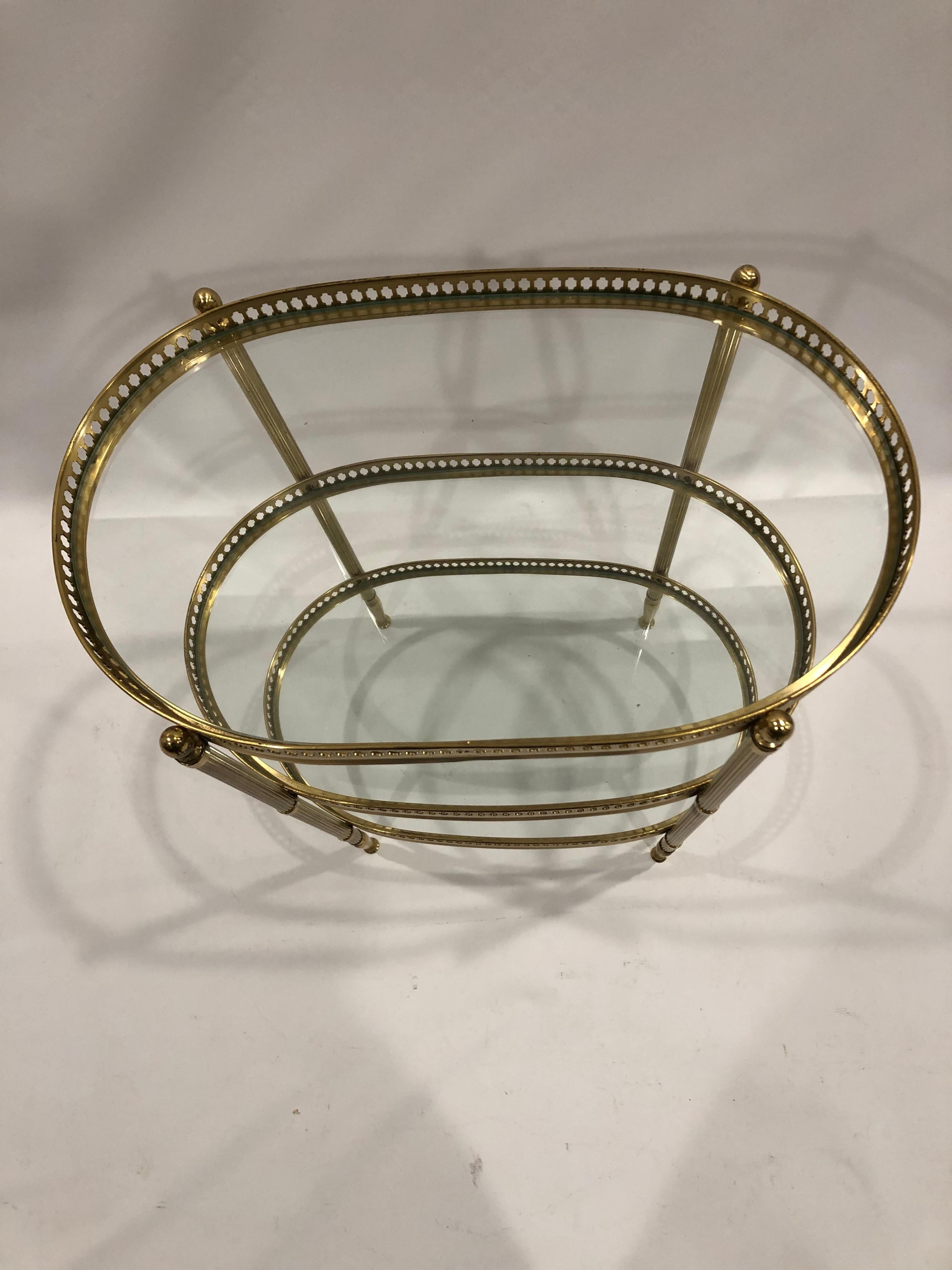 Beautifully designed side or end table having 3 levels of oval glass surfaces and lovely brass pierced galleries. Legs are brass and reeded with pretty finished small ball feet.