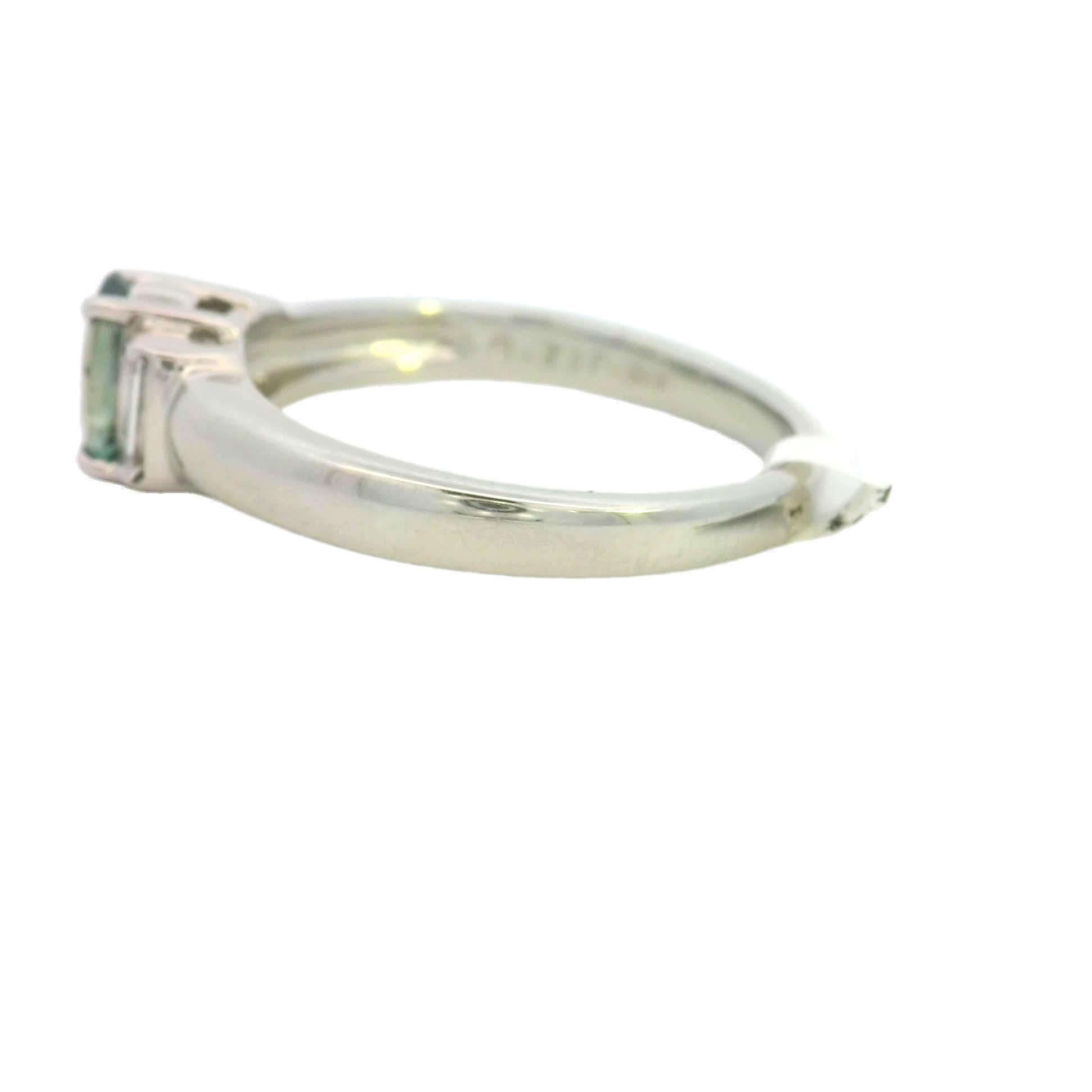 Scopri il fascino di questo splendido anello con gemma ovale, caratterizzato da un'affascinante pietra centrale verde acqua affiancata da due scintillanti diamanti a baguette. Realizzato con precisione, questo anello è perfetto per chi apprezza i