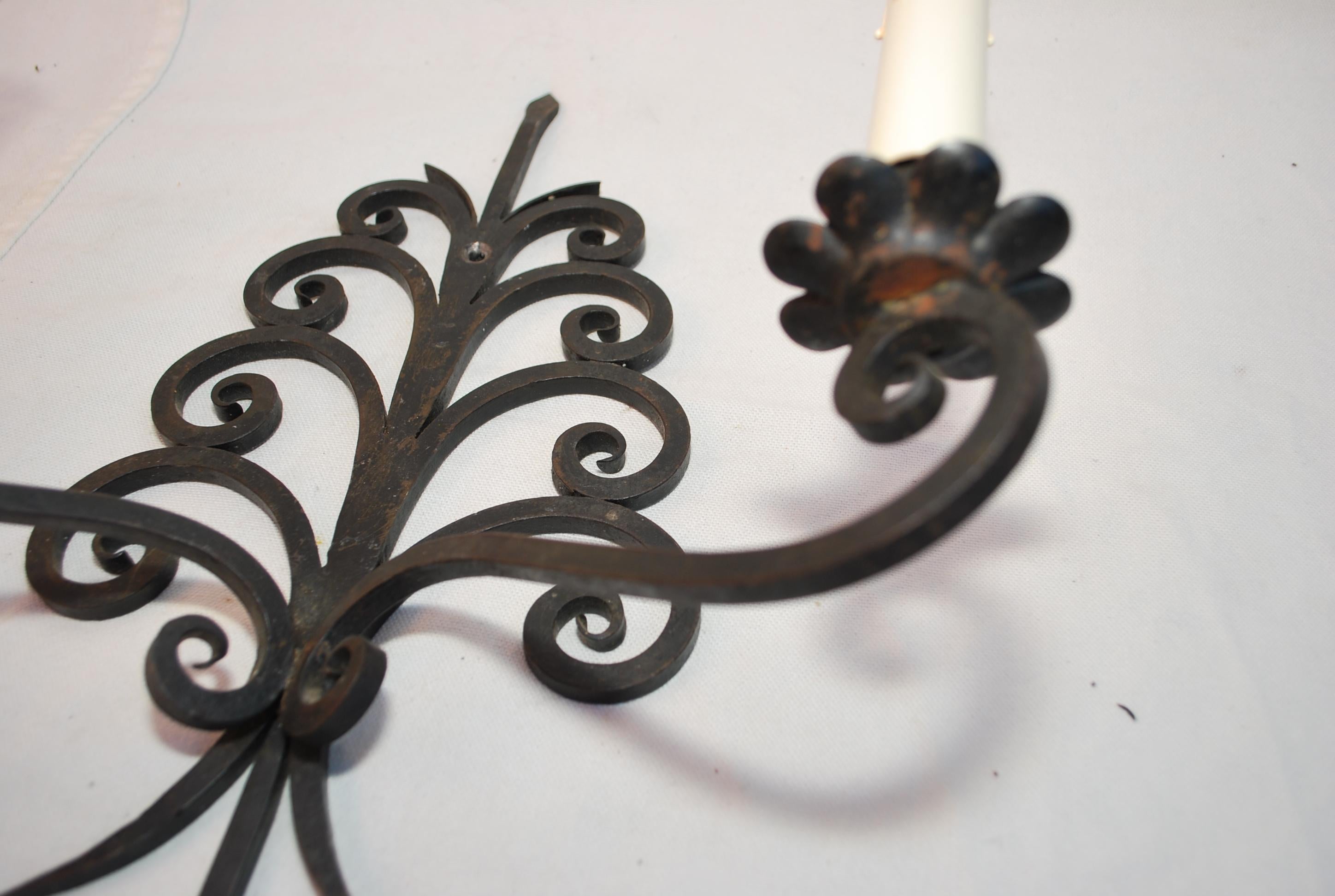 An elegant pair of french 1920's wrought iron sconces, the patina is so much nicer in person, we can put a round plate in the center to cover the electric box if it  is necessary , since we rewire all our lights,  ( no extra charge )