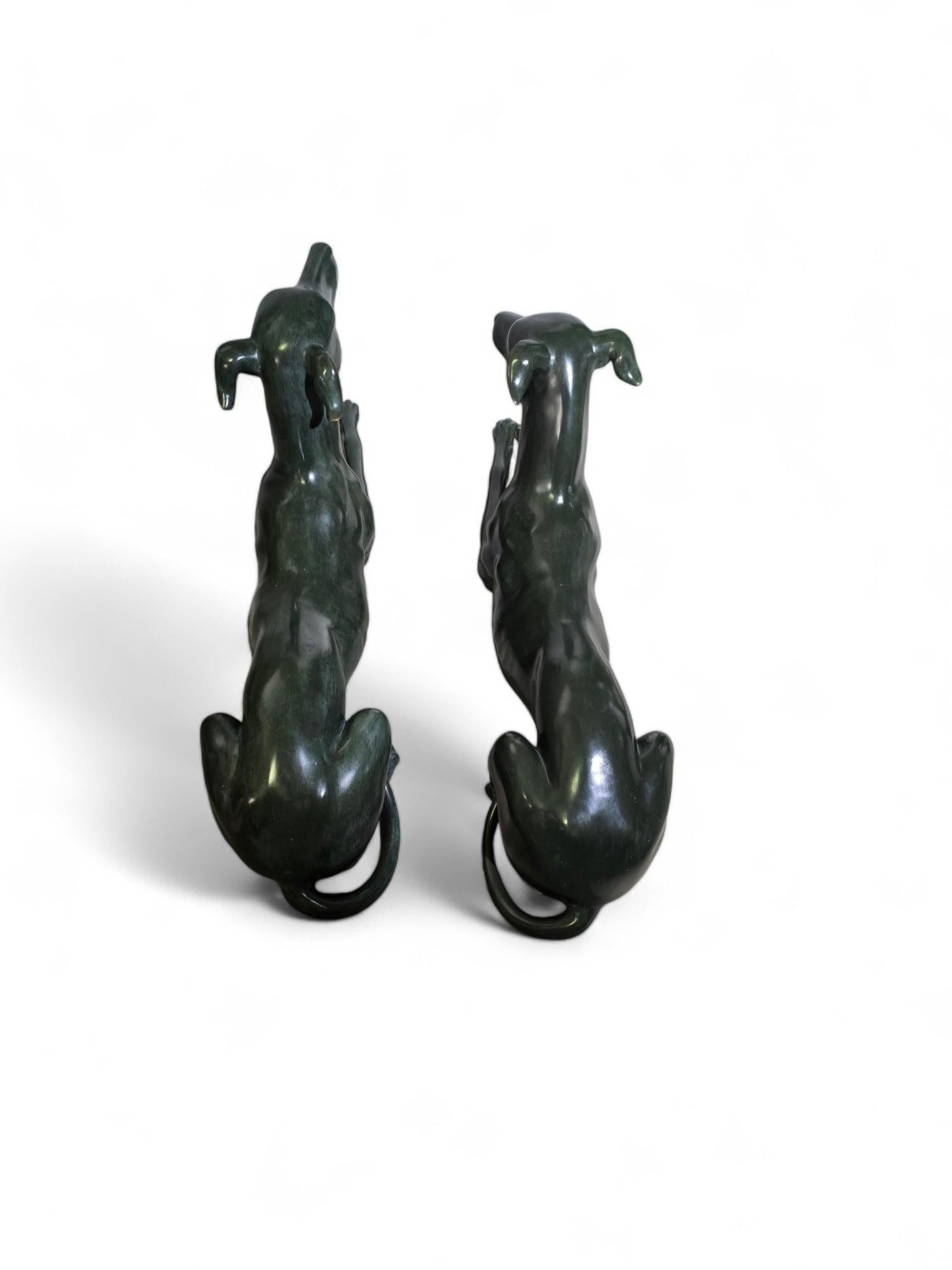 Questa sofisticata coppia di sculture di levrieri italiani degli anni '50 è realizzata in bronzo patinato verde e mette in mostra l'eleganza e la grazia di questi cani iconici. Le statue sono in perfette condizioni e rappresentano un'aggiunta
