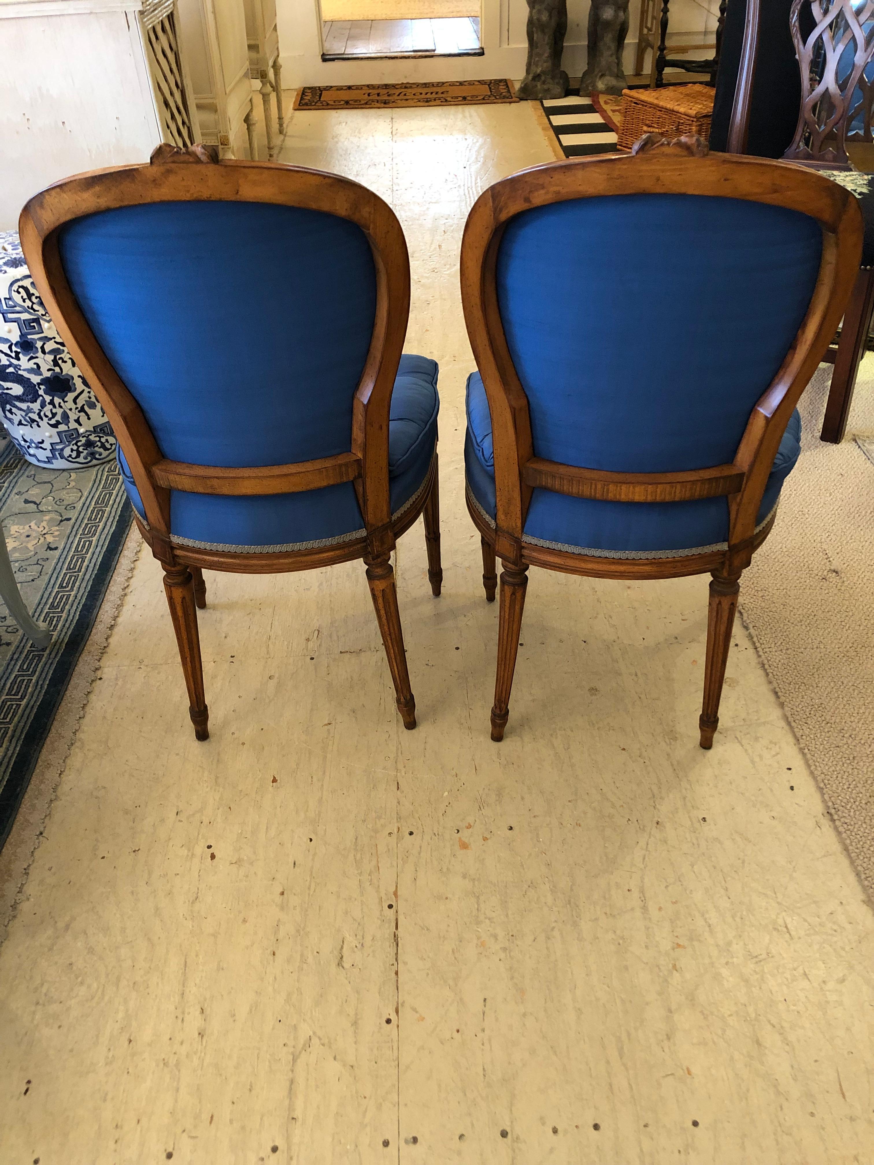 Very elegant pair of antique salon or side chairs having French Louis XVI style carved wood frames and striking cobalt blue upholstery. Tufted pillow top seat cushions are attached and plush.
JG