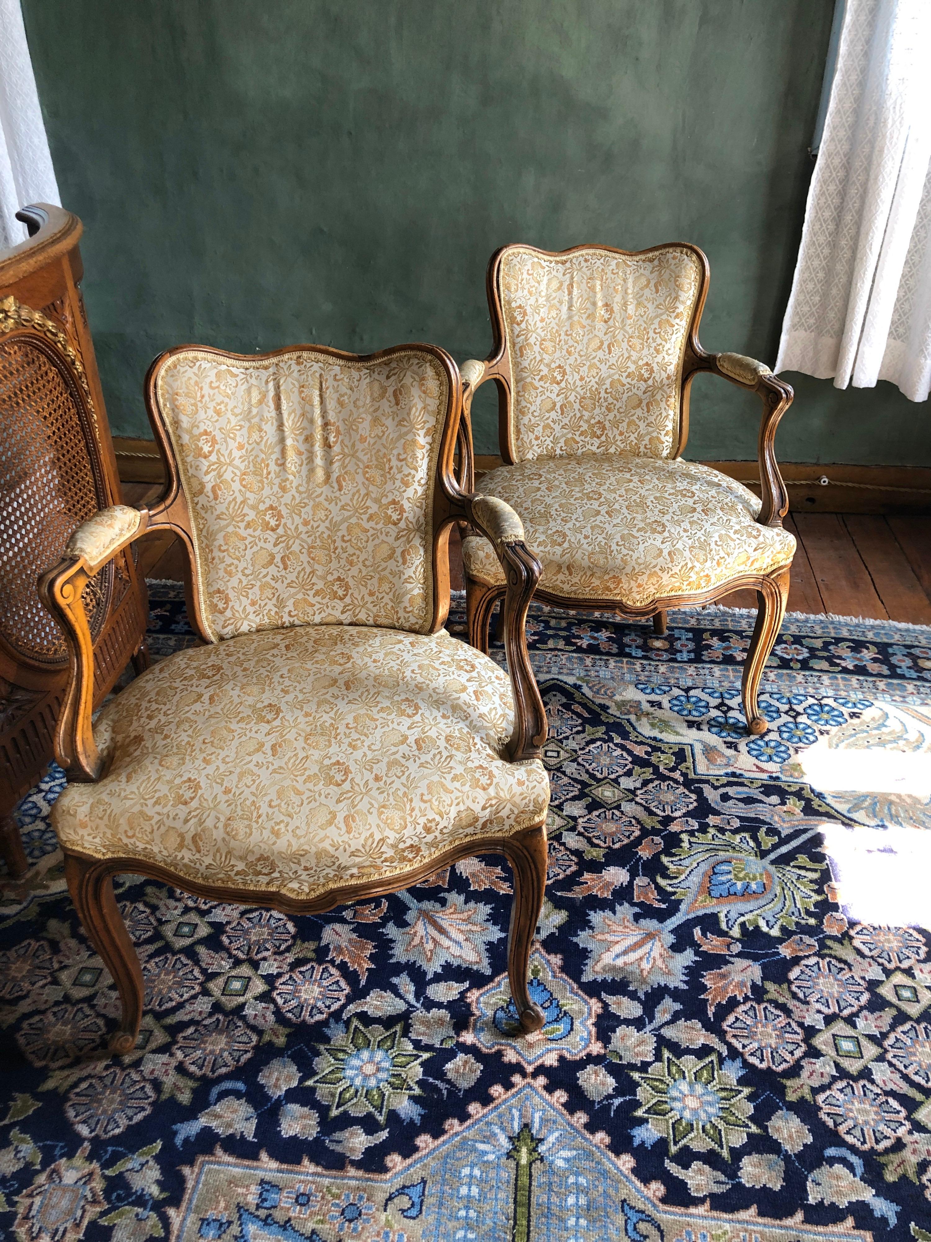 Ein Paar antike Sessel aus Frankreich. Diese Stühle sind aus massivem Nussbaumholz mit geschwungenen Beinen und Rückenlehne gefertigt und mit einem beigen Stoff mit Blumenmotiven neu gepolstert worden. Sehr komfortabel und gemütlich. Sehr guter