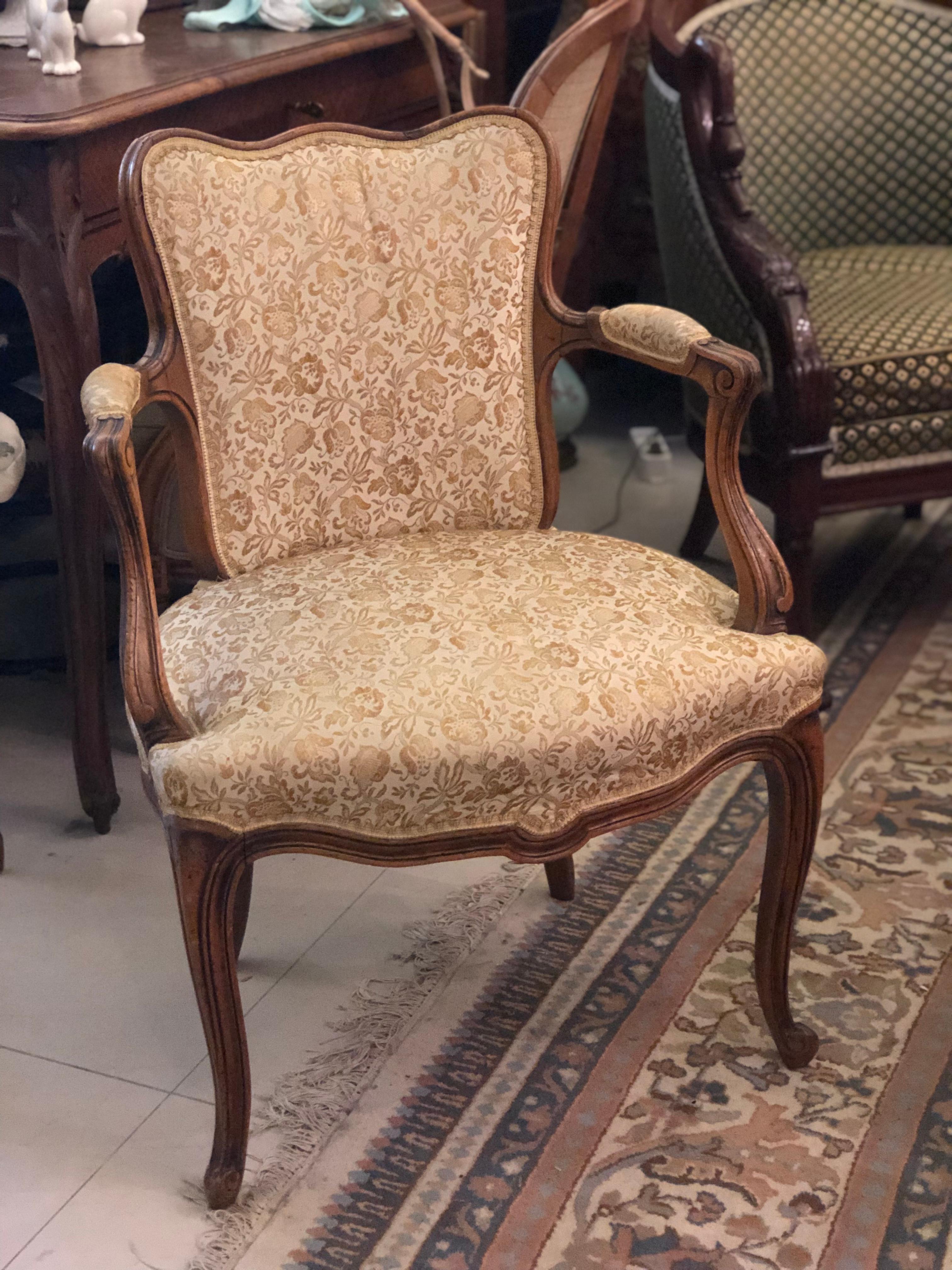 Pair of antique armchairs from France. These chairs are made of solid walnut with curved legs and back and have been reupholstered with a beige fabric with floral motifs. Very comfortable and cozy. Very good condition, France, circa 1880.