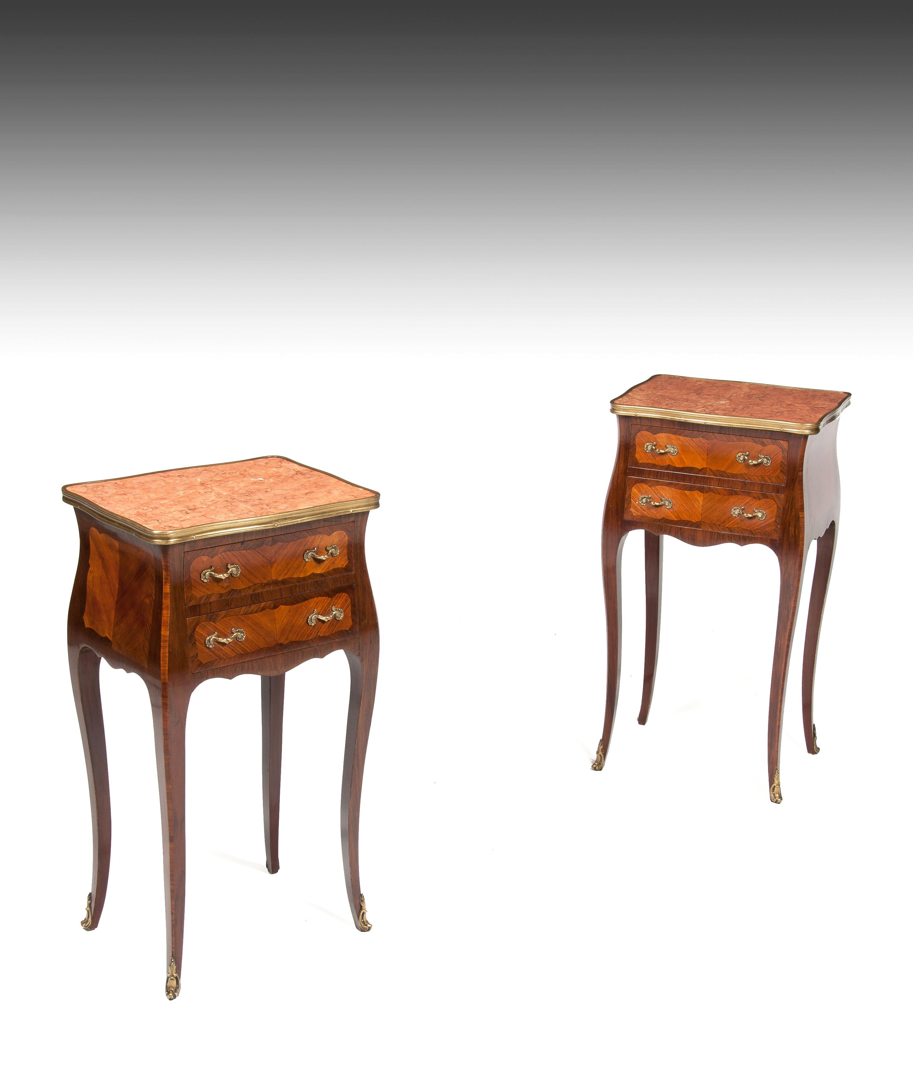 An elegant pair of finely constructed French rosewood and kingwood marble top beds cabinets.

French, circa 1900.

The serpentine pink marble tops within a looped strapwork over a bombe shaped rosewood body, enclosing two drawers, with shaped