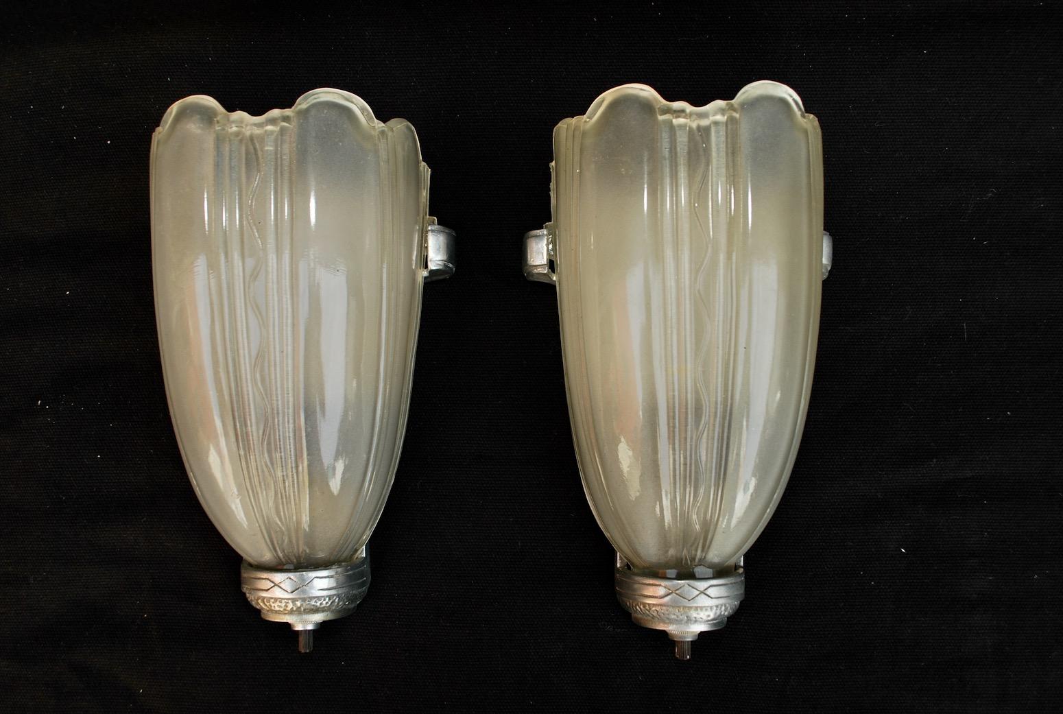 A sexy pair of 1920s Art Deco sconces, the glass is a little whiter and nicer in person, you can see in one picture, I think it is the flash of the camera that change the color of the glass.

 