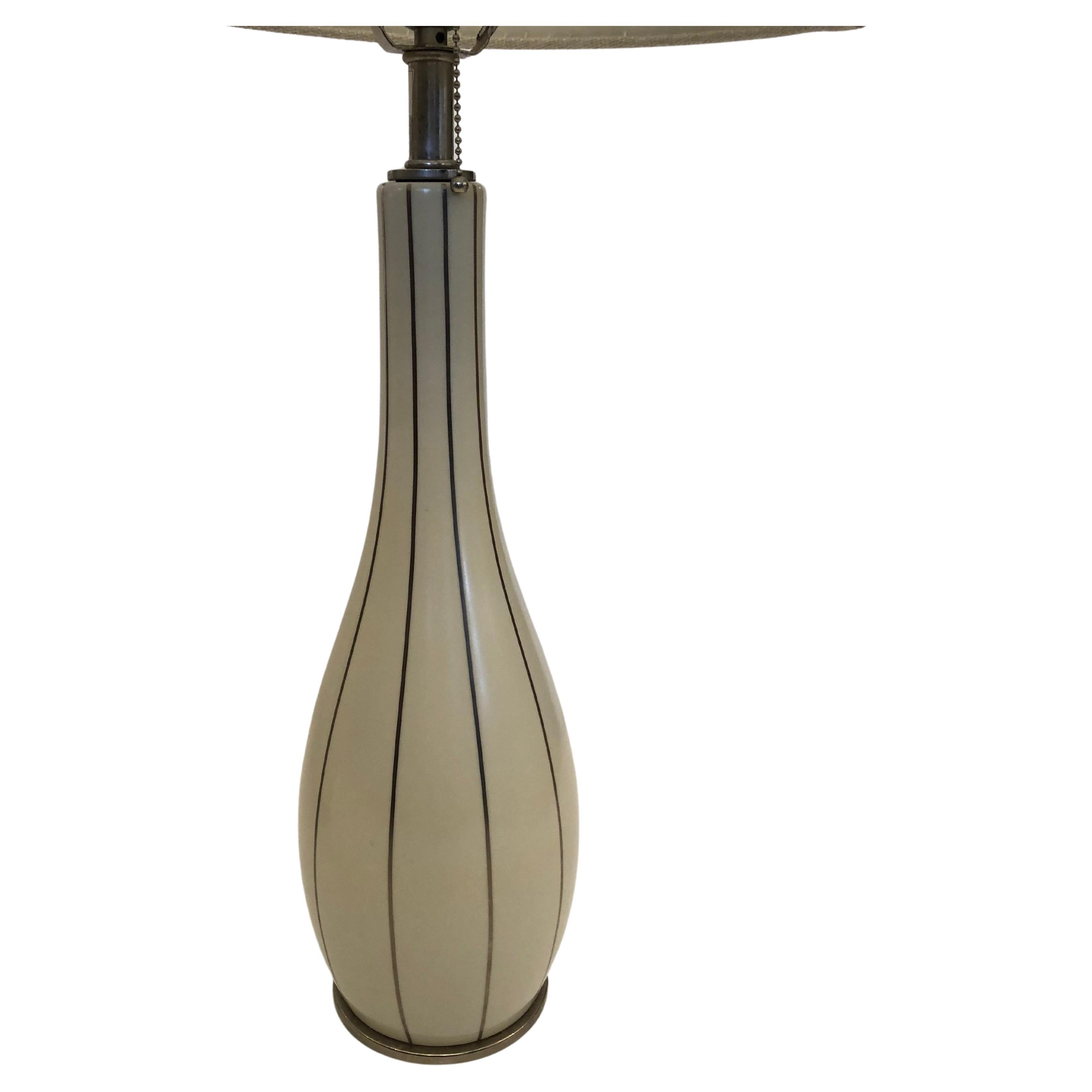 Sleek elegant pair of Barbara Barry swan design table lamps having a sensuous elongated vase shaped cream color lamp with inlay vertical silver bands.
Silver bases. Shades included.
Vase shaped lamp itself is 18.5 H 32.5 H to finial.