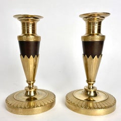 Elegantes Paar Empire-Kerzenständer aus vergoldeter und dunkel patinierter Bronze. 1820er Jahre