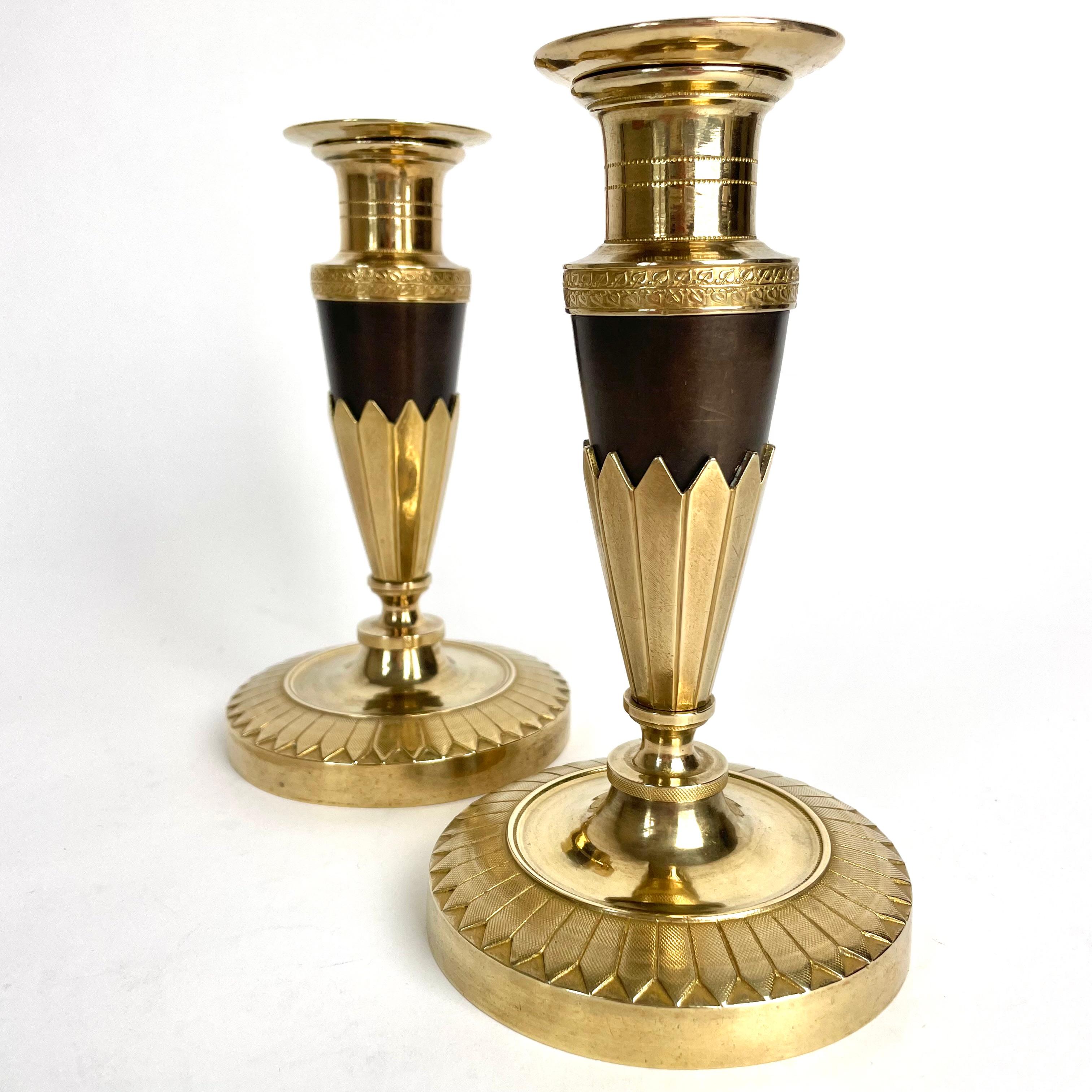 French Elegant pair of Empire Candlesticks in gilt and dark patinated bronze. 1820s For Sale