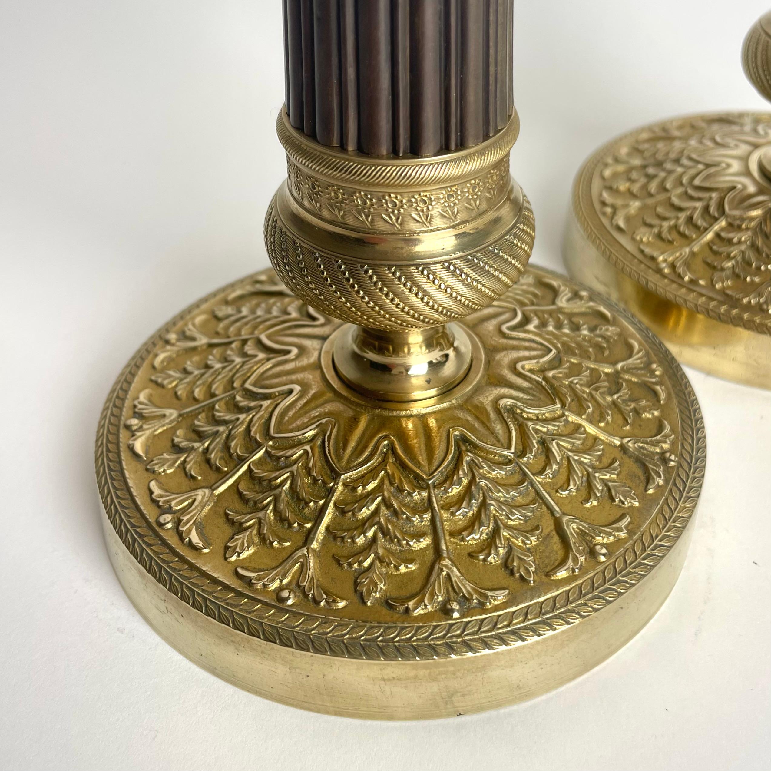 Elegante pareja de candeleros Imperio en bronce dorado y patinado oscuro. 1820s Dorado en venta