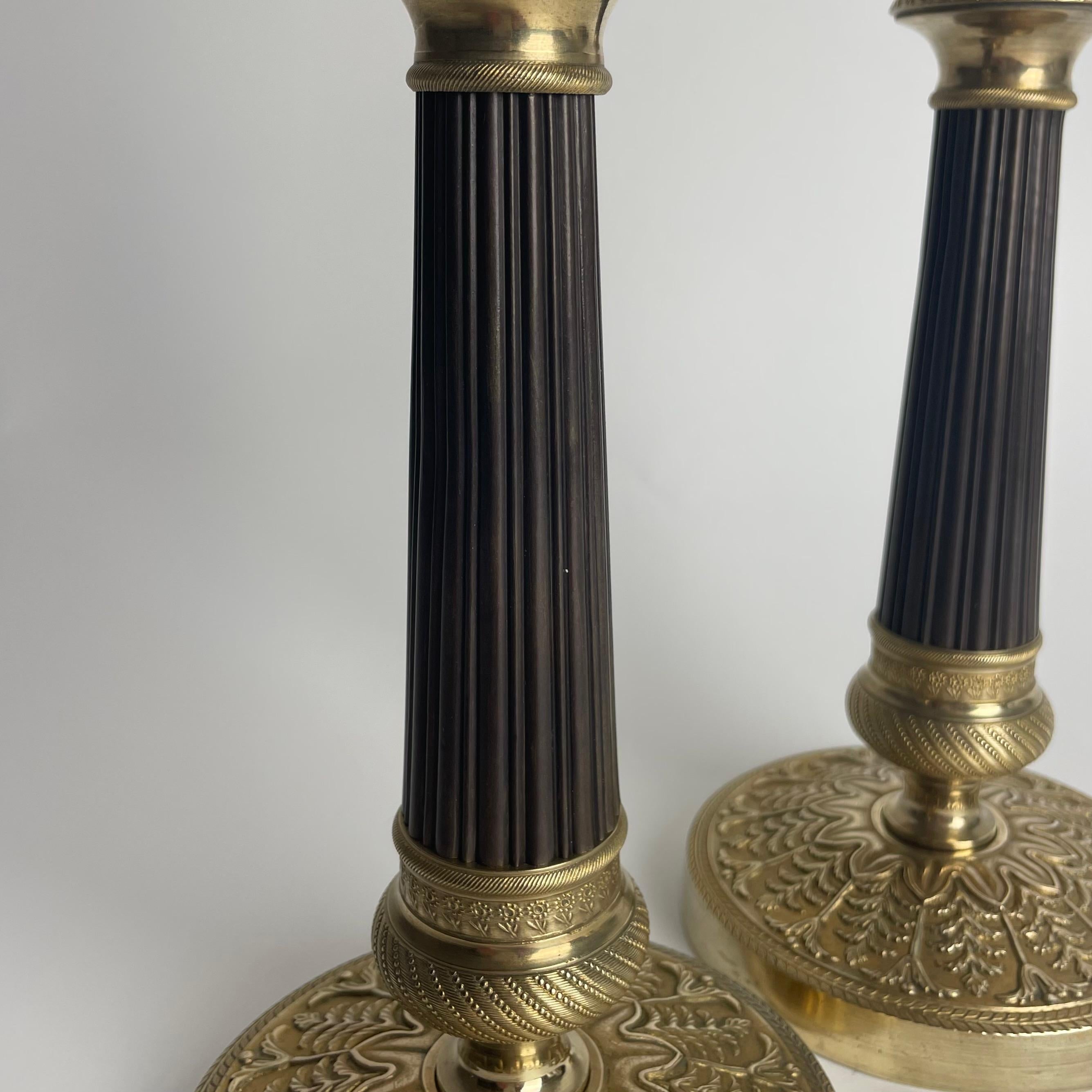Elegante pareja de candeleros Imperio en bronce dorado y patinado oscuro. 1820s en Bueno estado para la venta en Knivsta, SE