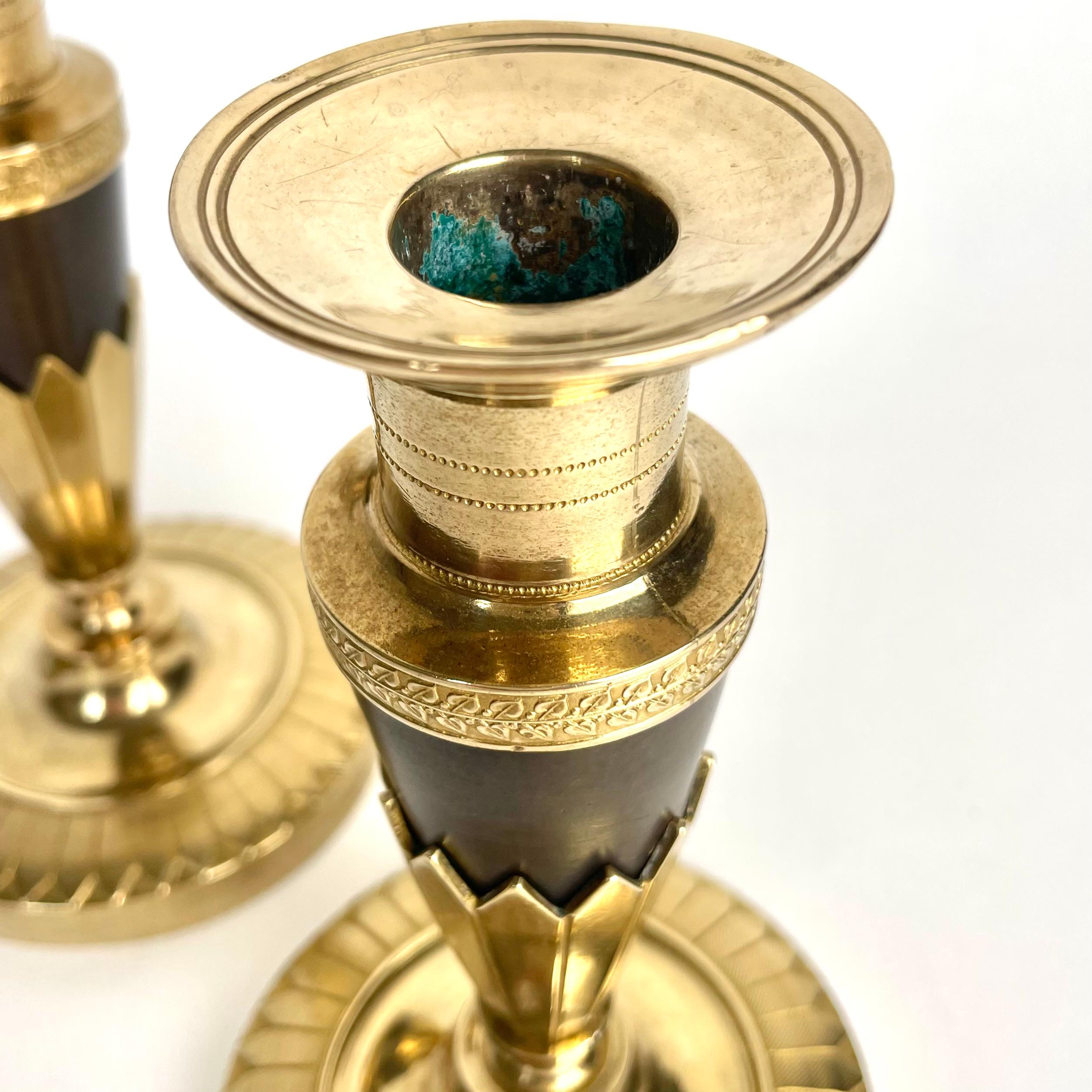Early 19th Century Elegant pair of Empire Candlesticks in gilt and dark patinated bronze. 1820s For Sale