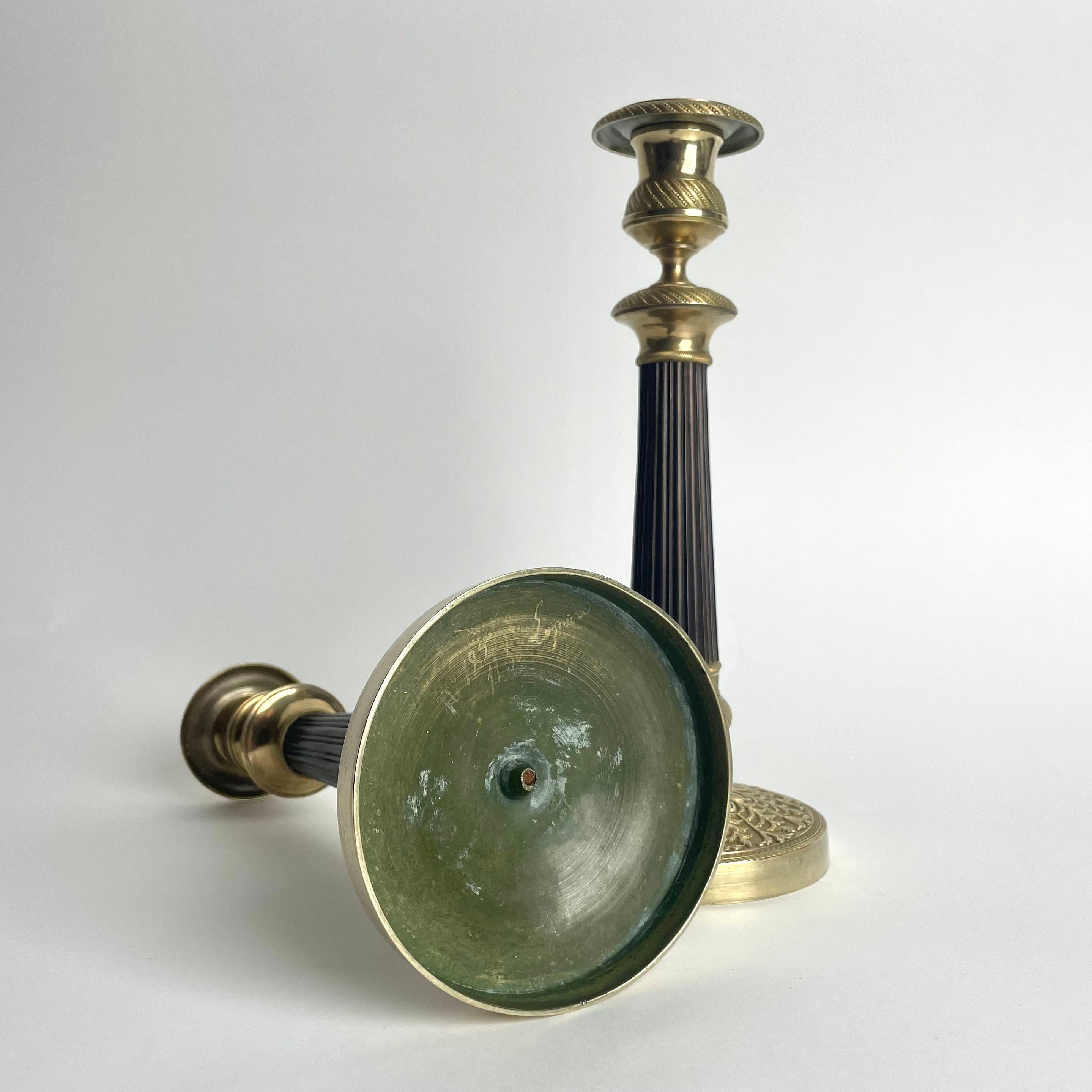 Elegante pareja de candeleros Imperio en bronce dorado y patinado oscuro. 1820s en venta 1