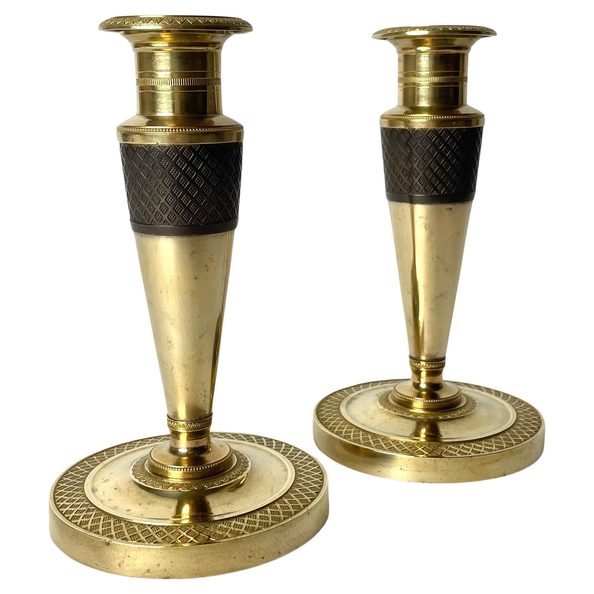 Elegant pair of Empire Candlesticks in gilt and dark patinated bronze. 1820s