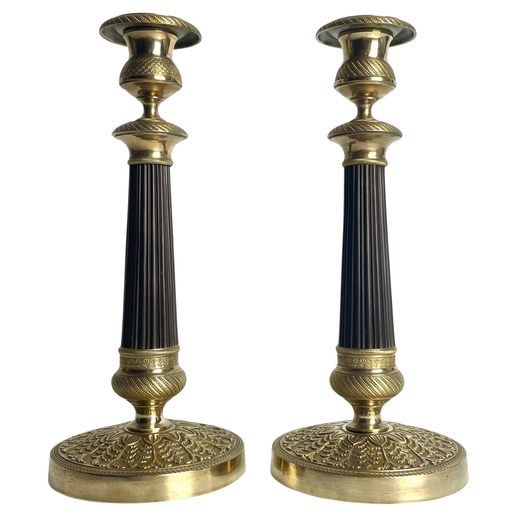 Elegante pareja de candeleros Imperio en bronce dorado y patinado oscuro. 1820s