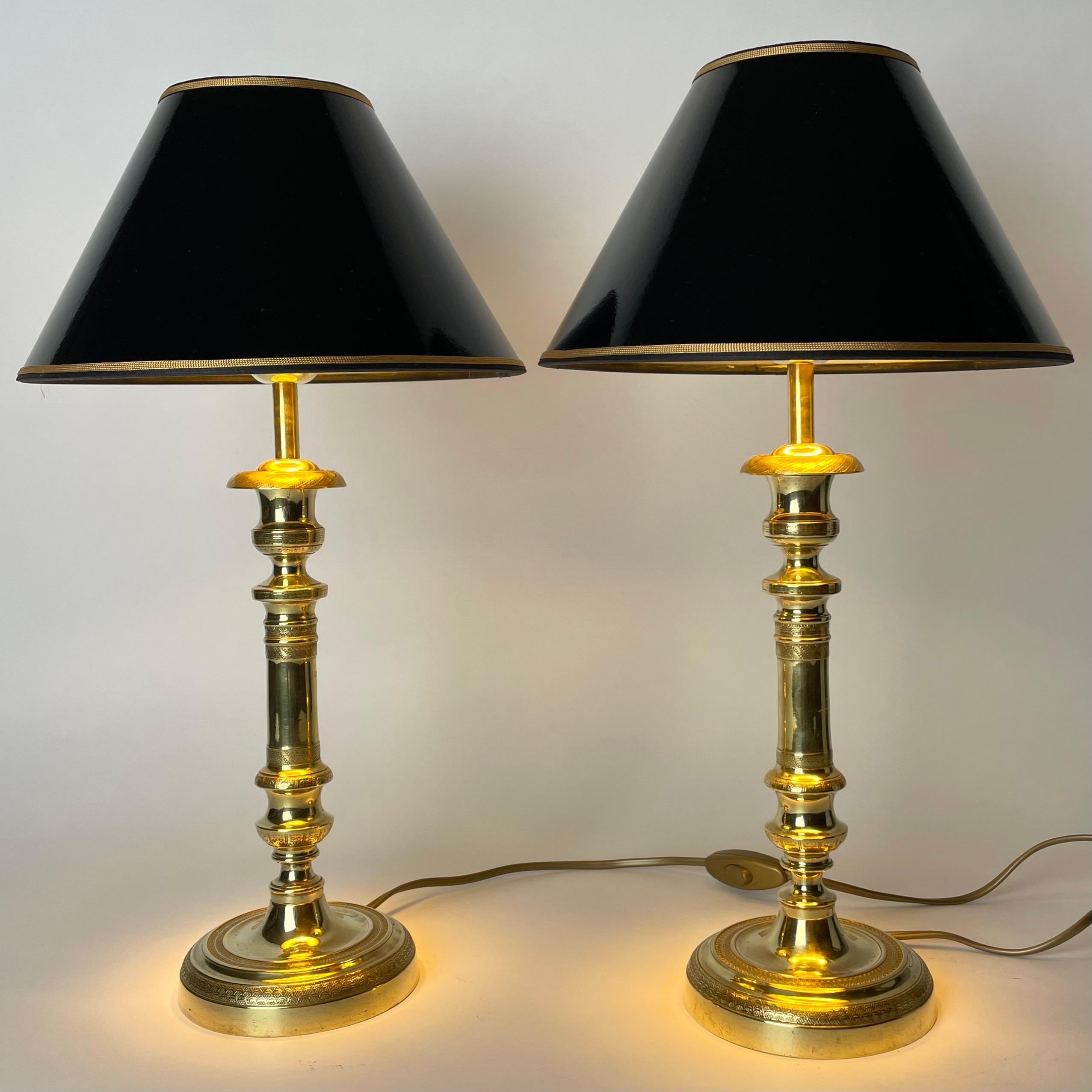 Elegantes Paar Empire-Tischlampen in Bronze. Ursprünglich ein Paar Empire-Leuchter aus den 1820er Jahren, die Anfang des 20. Jahrhunderts zu Tischlampen umfunktioniert wurden.

Neu verkabelte Elektrizität 

Neue Lampenschirme aus schwarzem Lack mit