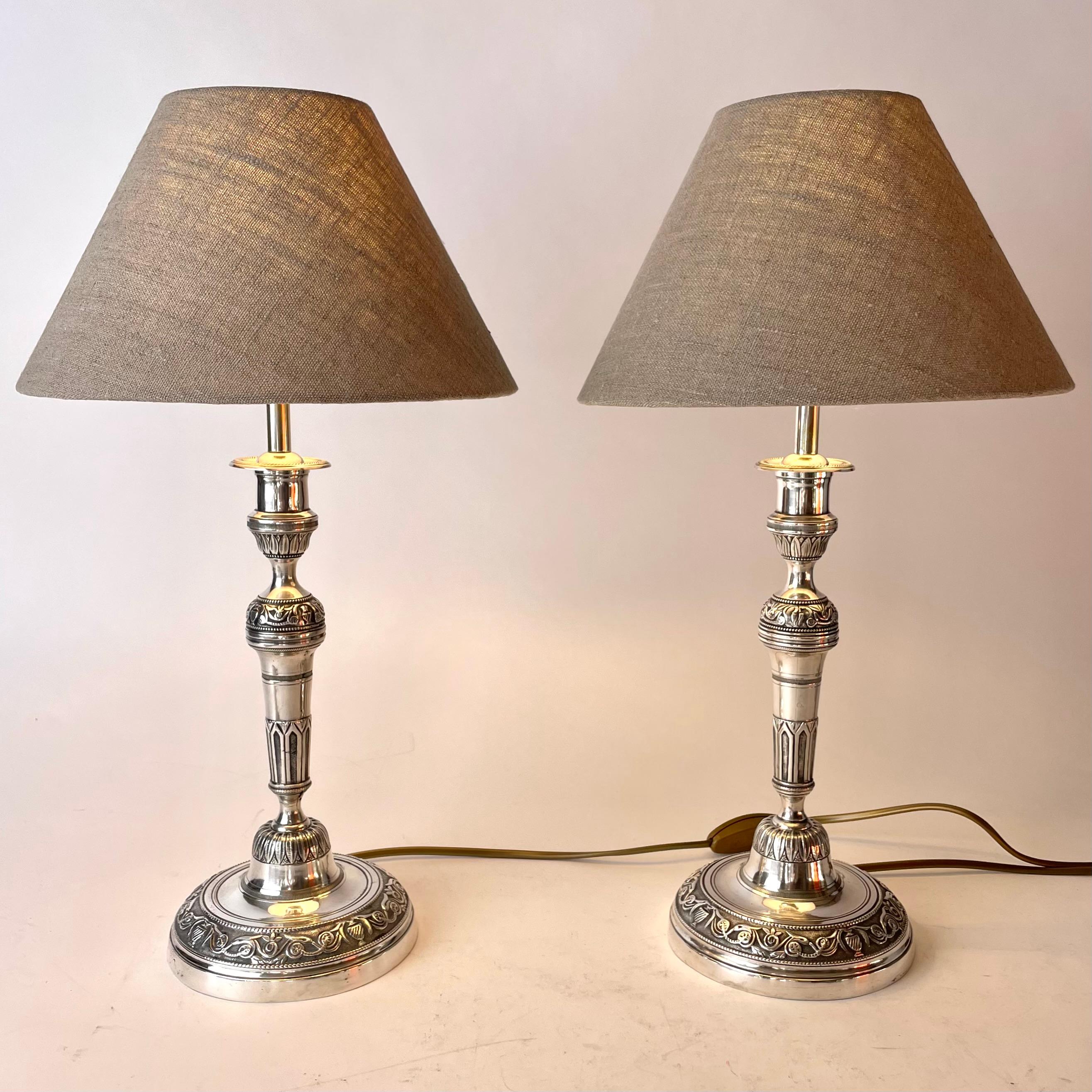 Elegantes Paar Empire-Tischlampen aus versilberter Bronze. Ursprünglich ein Paar Empire-Leuchter aus den 1820er Jahren, die Anfang des 20. Jahrhunderts zu Tischlampen umfunktioniert wurden.

Neu verkabelte Elektrizität 

Neue Lampenschirme aus