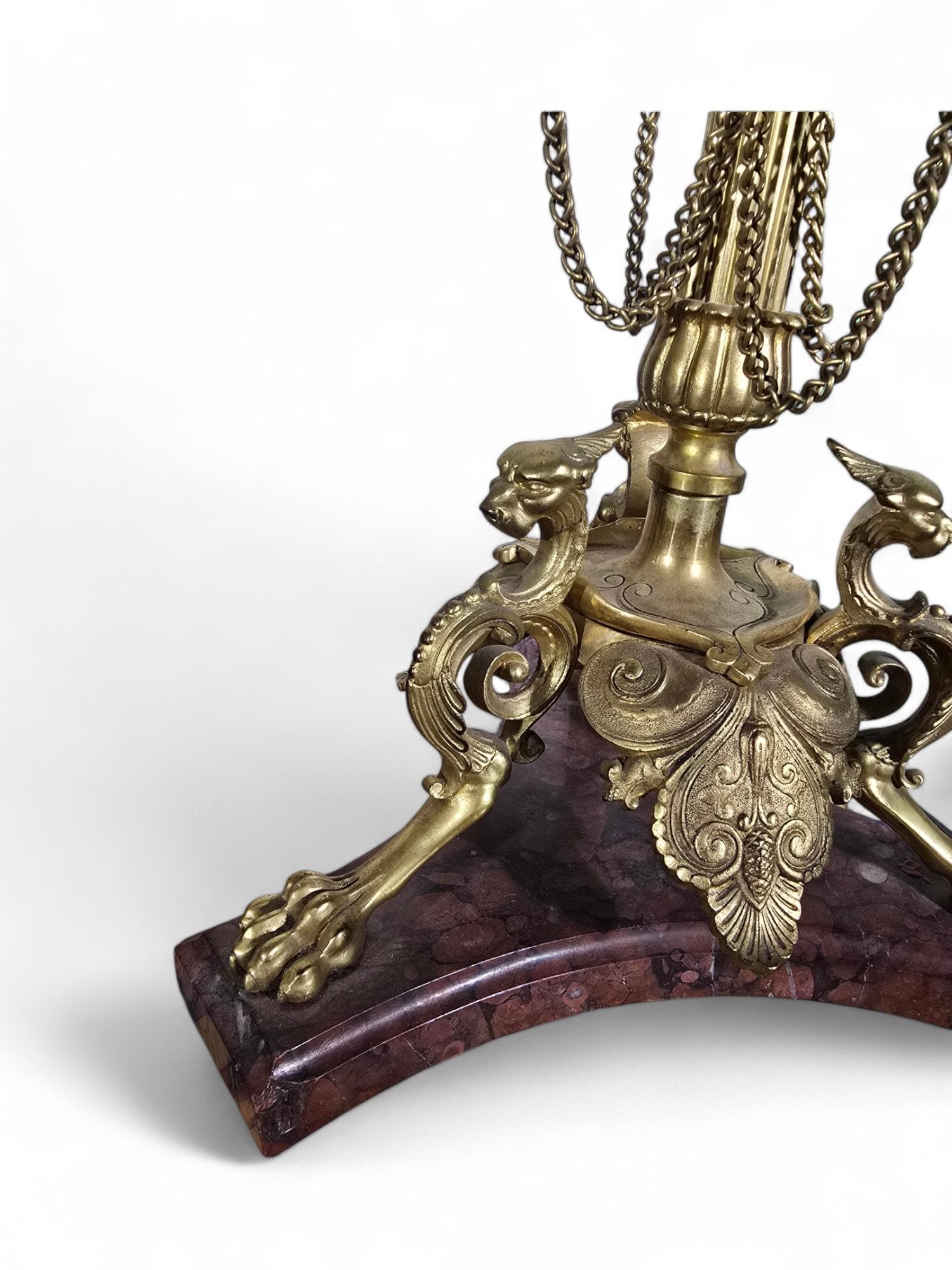 Esta exquisita pareja de candelabros franceses del siglo XIX está elaborada en bronce finamente cincelado al estilo griego. Cada candelabro presenta una lujosa base de mármol rojo real, que añade un toque de opulencia y elegancia clásica. Estos