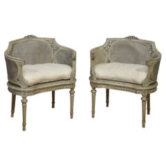 Elegante paire de chaises à baignoire françaises sculptées et cannées de style Louis XVI