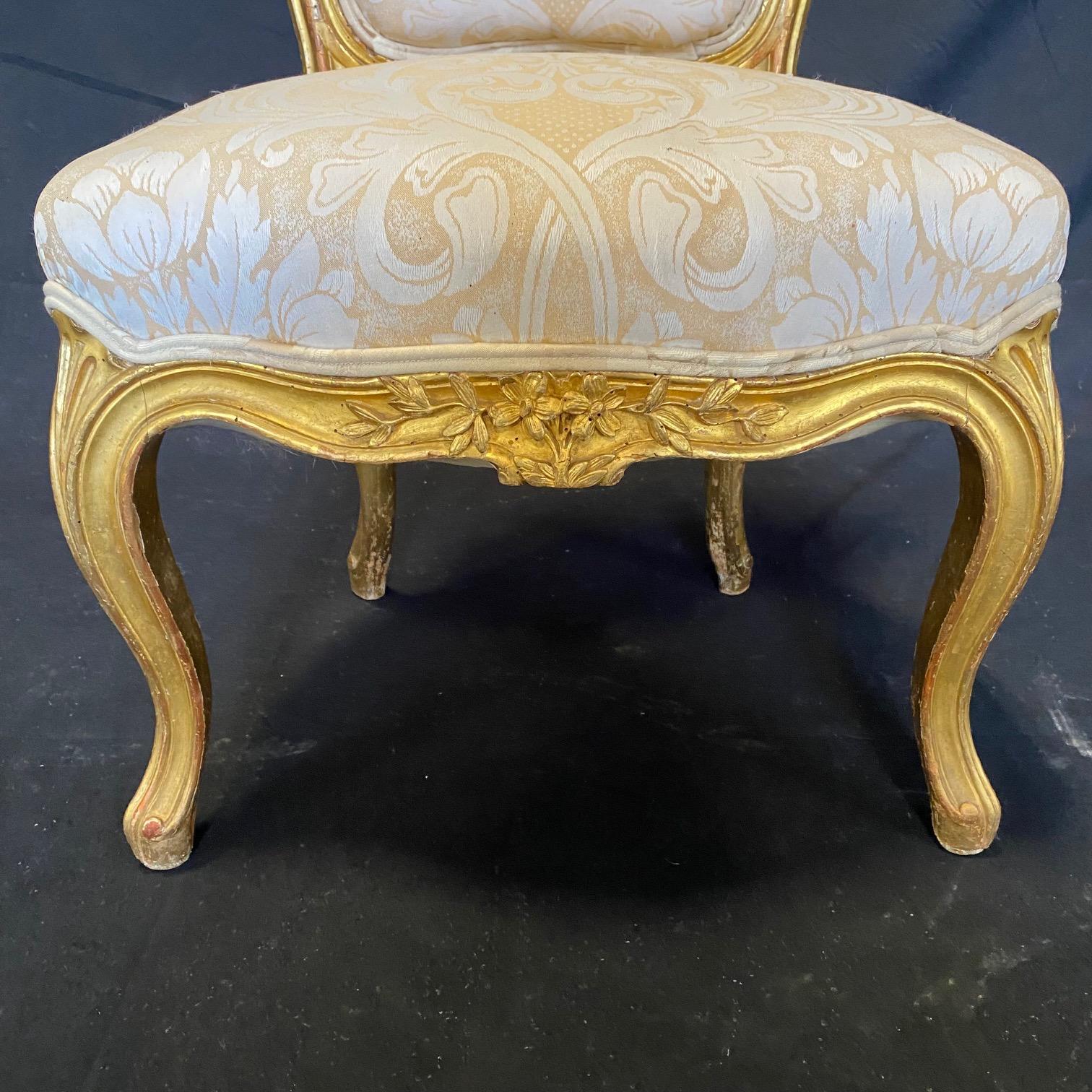 Really lovely pair of French Louis XV giltwood antique slipper chairs with intricate floral carving on the apron and top of backrest. The single window pane on the back is a nice touch. #2255