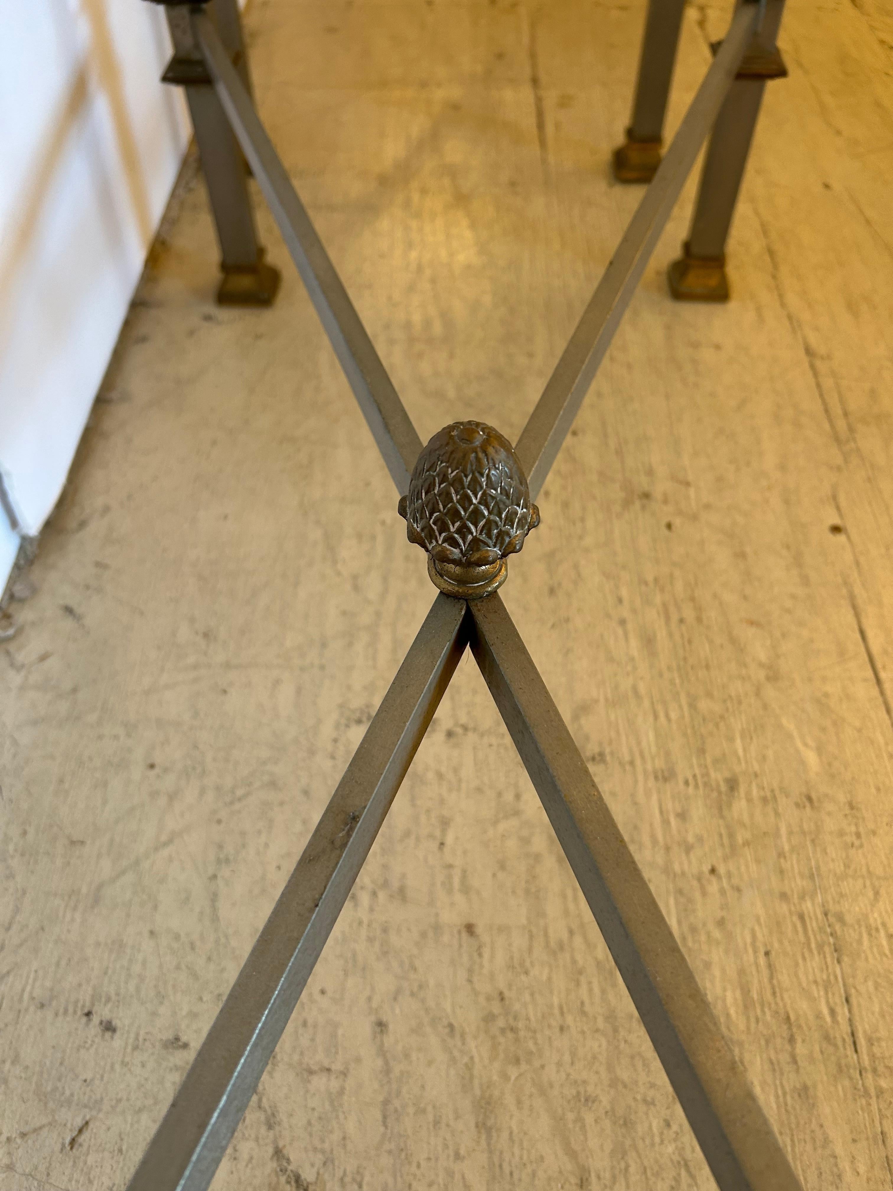 Squisita coppia d'epoca di consolle francesi Maison Jansen in acciaio, bronzo e vetro, con le classiche gambe a X e la ghiera centrale.