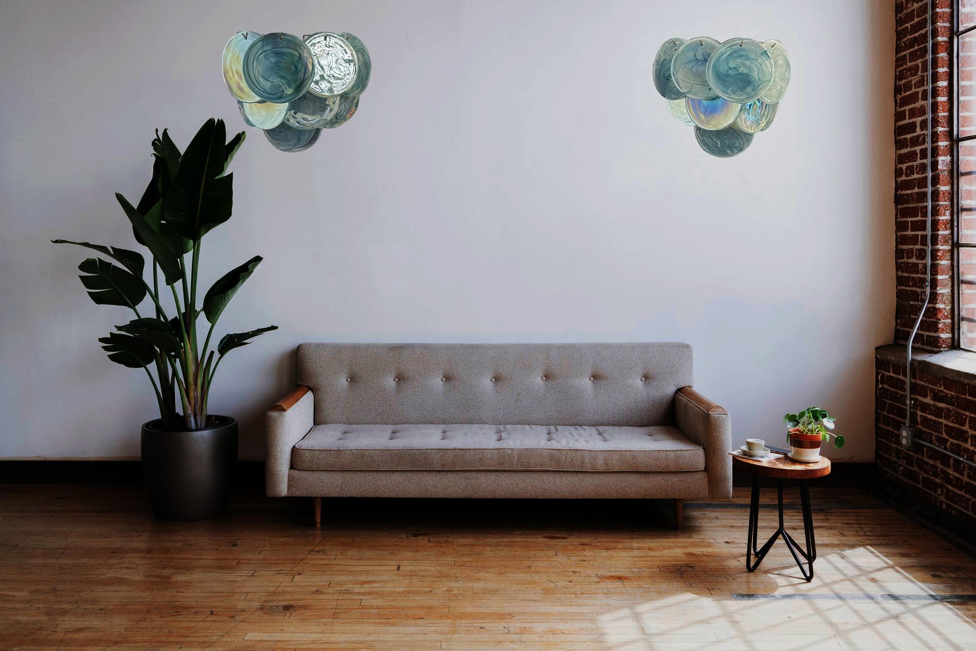 
Pair of Vintage Italian Murano appliques in Vistosi style. Wall lights have 10 glass for each, iridescent alabaster blue discs. The glasses are now unavailable, they have the particularity of reflecting a multiplicity of colors, which makes the
