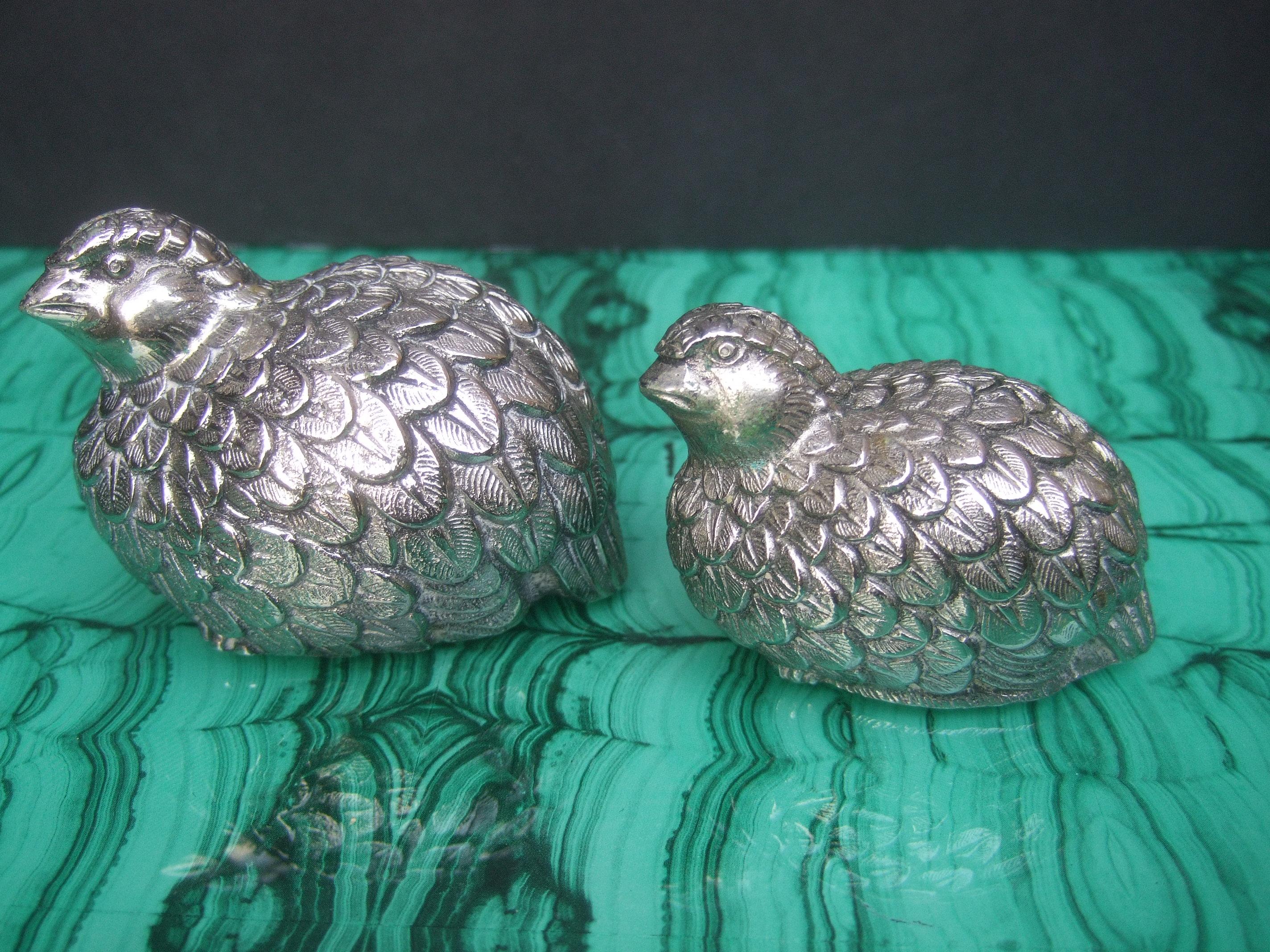 Elegant pair of Gucci Italian silver metal quail salt & pepper shakers c 1970s
The charming quails have etched & impressed detail that emulates their plumage  

Makes an elegant dining table decorative collectible
The pair of quails are graduated