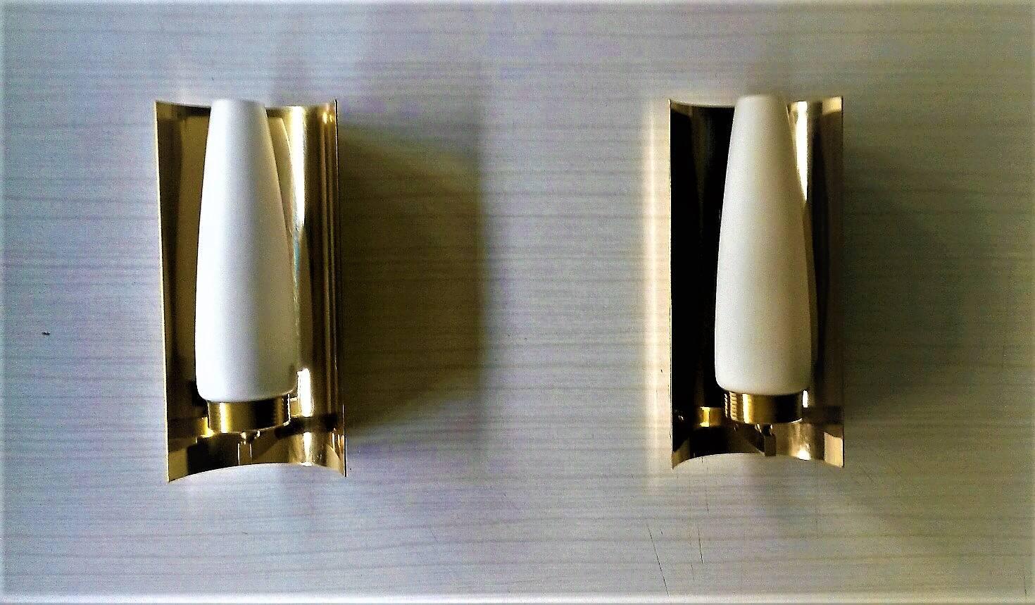 Very elegant French Mid-Century Modern pair of sconces with a brass reflector and satin white opalines by Maison Arlus editions, France, circa 1955.

In a very good general condition, the electric par has been renewed and follows the US standards