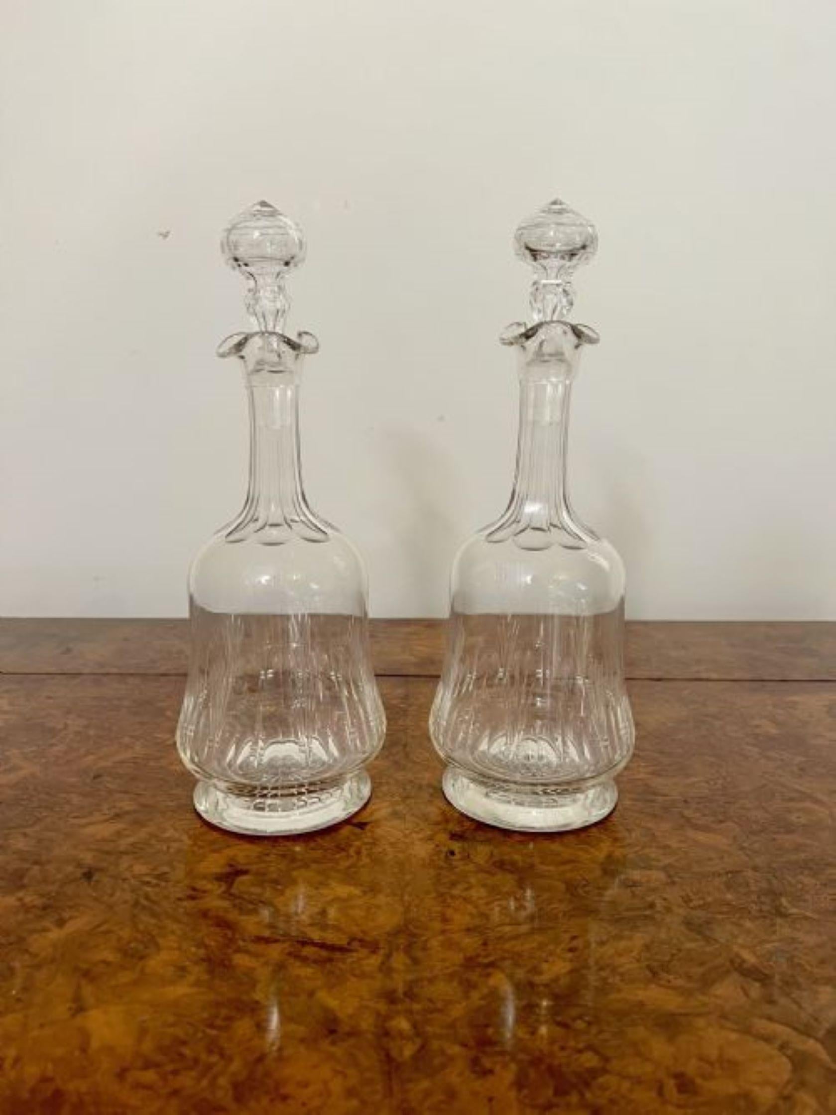 Elegant pair of quality antique Victorian decanters having an elegant pair of antique Victorian decanters with a lovely wavy shaped top, a shaped body standing on a circular base with the original cut glass stoppers. 