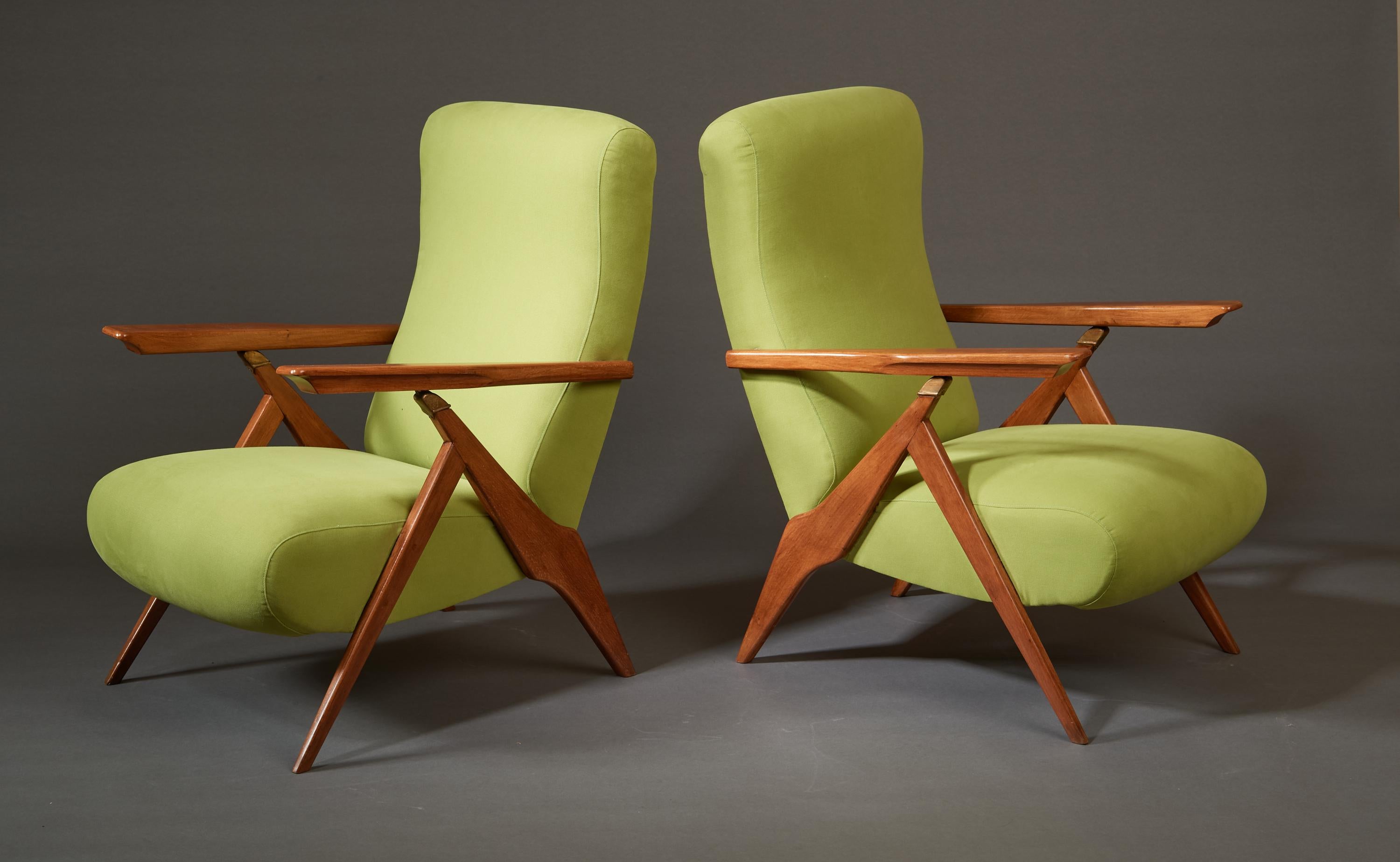 Italie, années 1950. 

Gracieuse paire de fauteuils inclinables réglables en bois fruitier teinté acajou avec détails en laiton, rembourrés en chartreuse claire. Les accoudoirs sculptés, reposant élégamment sur des ferrures en laiton, se soulèvent