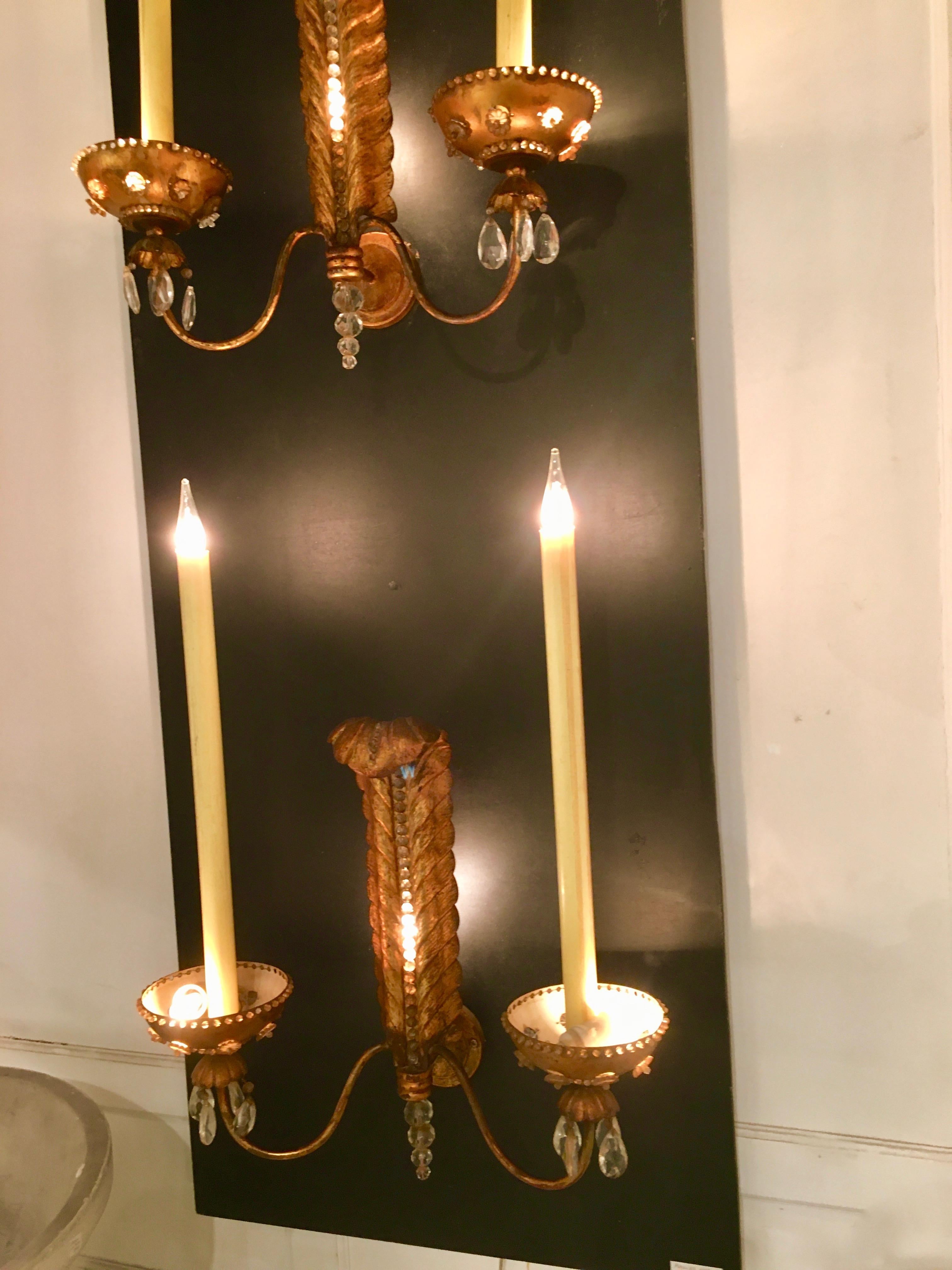 Spectacular pair of sconces with gilt metal and crystals. 
Three lights each sconce.
By Maison Baguès 1950.
 