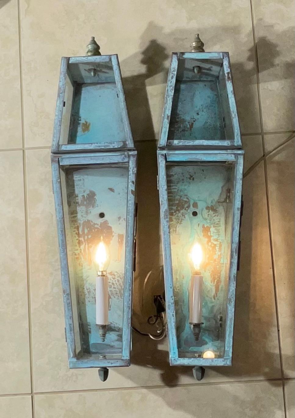 

Add a touch of timeless elegance and vintage charm to your home or outdoor space with this exquisite pair of solid brass wall-mounted lanterns. These funky fixtures boast a rich, turquoise patina that speaks to their look and offering a unique