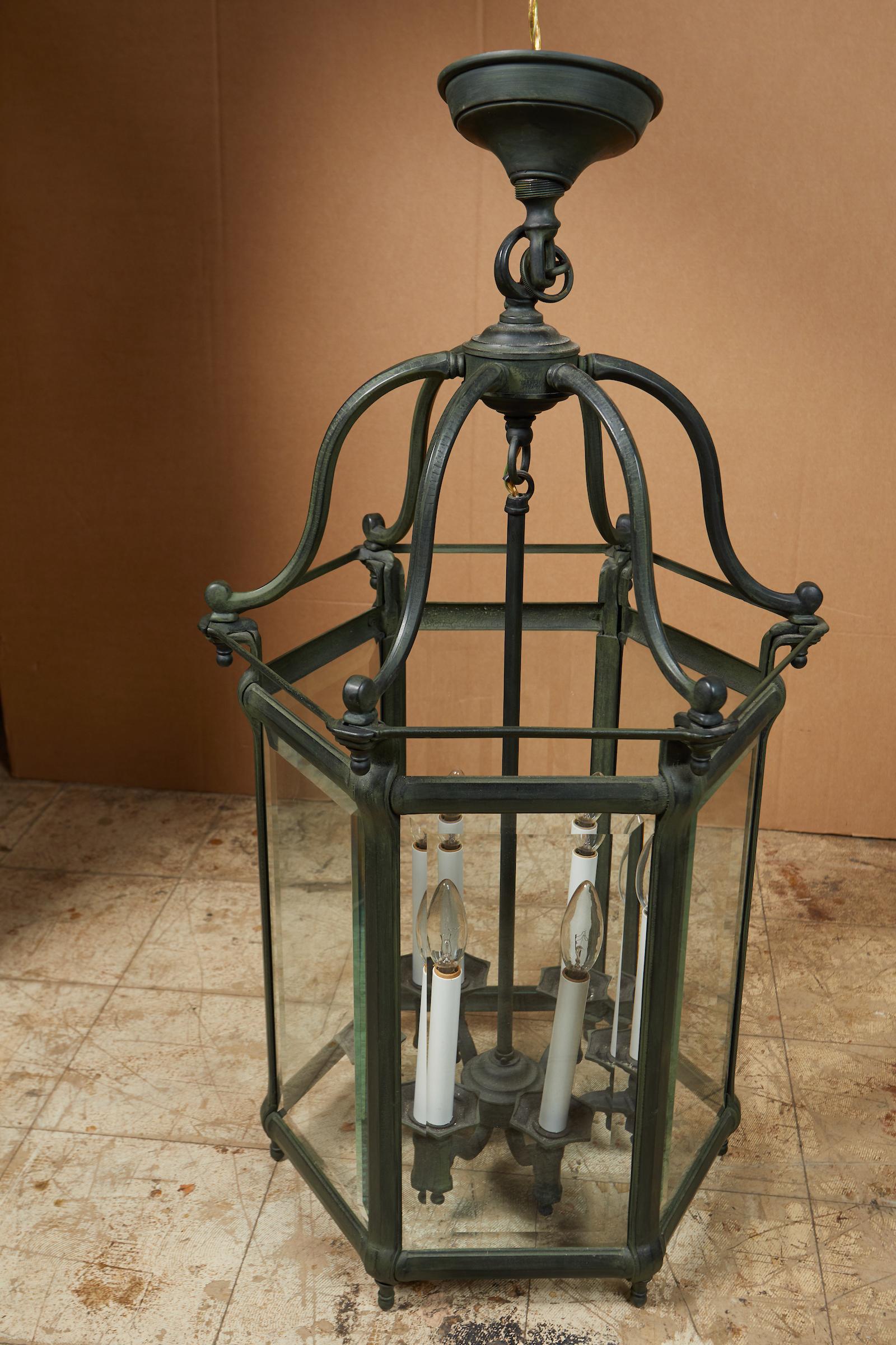 Elegant pair of solid green patinated bronze lanterns with hexagonal faceted beveled glass.