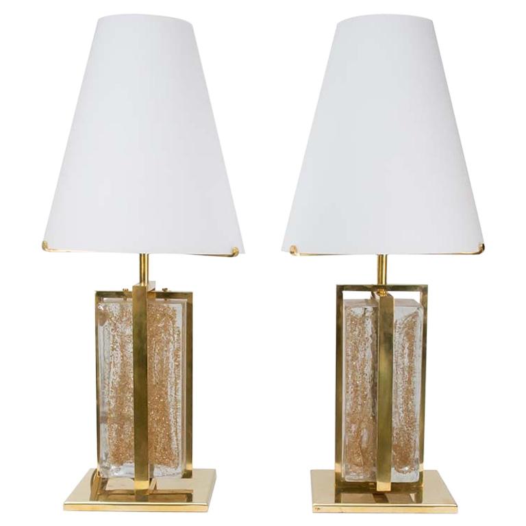 A very elegant pair of modernist table lamps. White satin blown glass shade in the form of a truncated cone mounted on a solid brass structure with a clear and gold inclusion blown glass shaped as a brick. Italian design 2000c. This pair of table