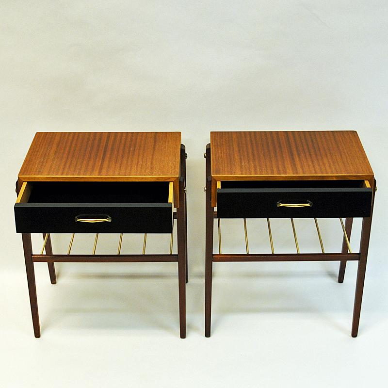 Petite and lovely pair of teak veneer and brass small tables with black painted drawers, brass handles and a brass shelf underneath. Brass details on the sides. Great as nigh tables or side tables alone or together. From Sweden, around the