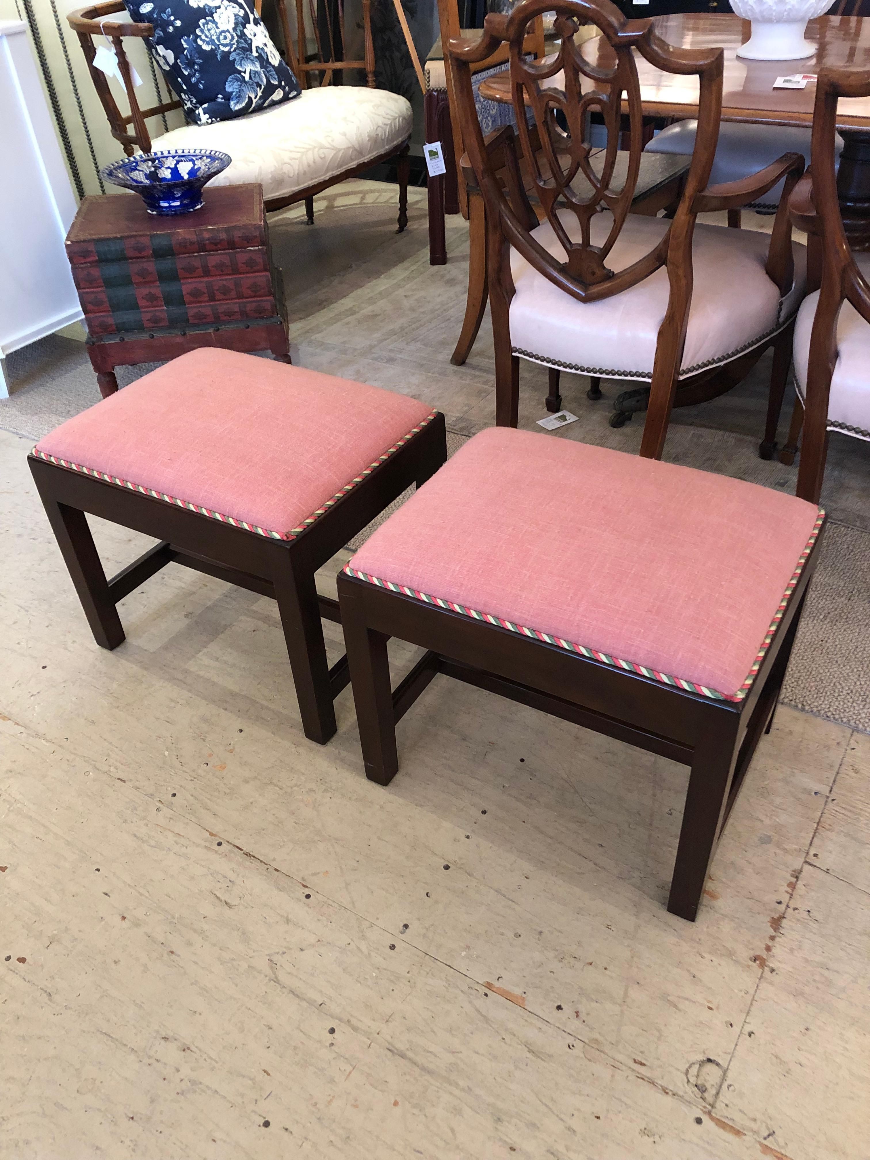 An elegant pair of vintage mahogany & rasberry linen upholstered traditional rectangular benches with decorative trim.